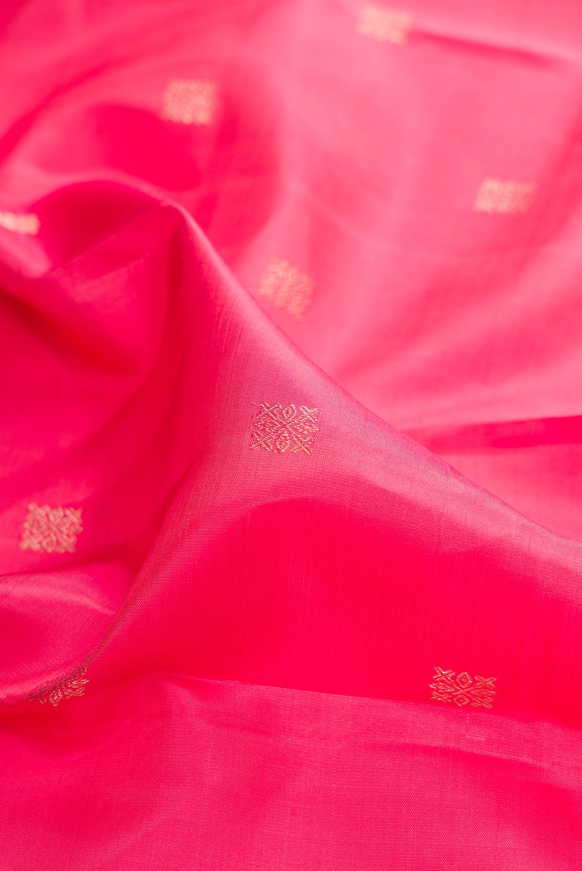 Close up of Pure Silk Pink Dual Tone Kanjivaram Saree with Zari Butta on the body and Fancy Border.  displaying folds