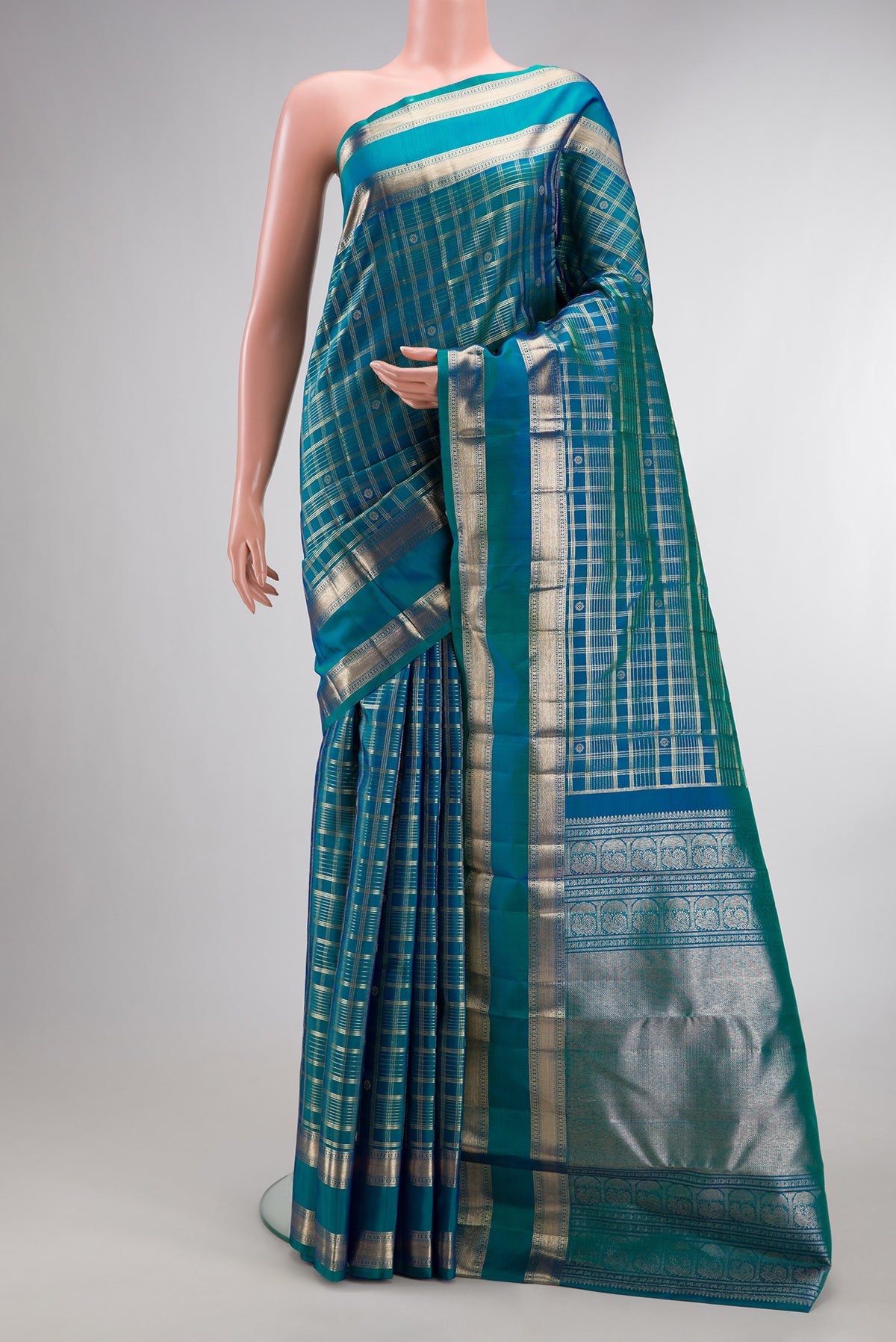 Pure Silk Peacock Blue Dual Tone Kanchipuram Saree with Checked design on the body and Zari Border.  displayed on a mannequin