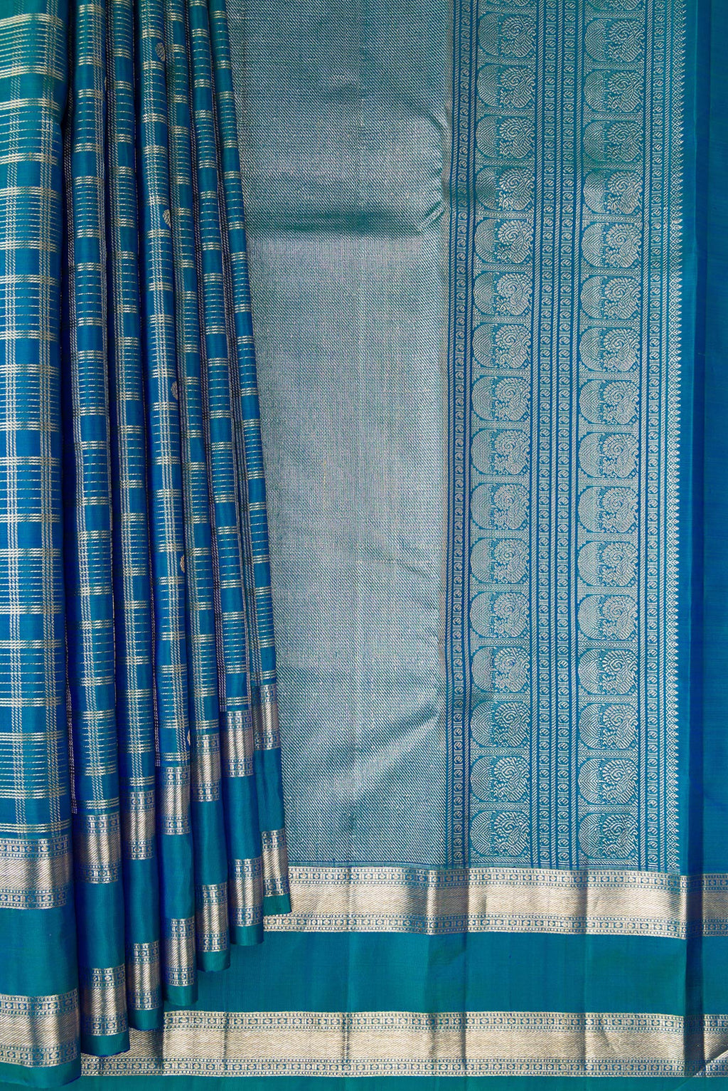Pleats and pallu of Pure Silk Peacock Blue Dual Tone Kanchipuram Saree with Checked design on the body and Zari Border. 