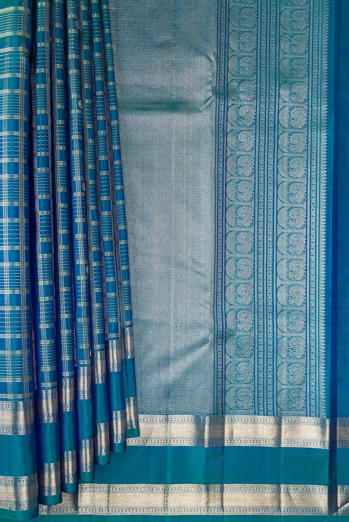 Pleats and pallu of Pure Silk Peacock Blue Dual Tone Kanchipuram Saree with Checked design on the body and Zari Border. 