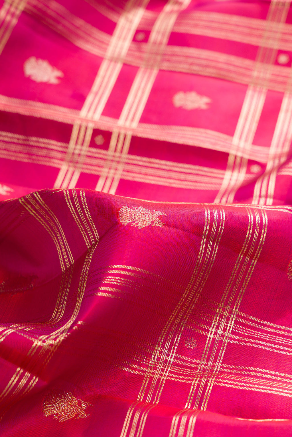 Close up of Pure Silk Dark Pink Dual Tone Kanchipuram Saree with Checked design on the body and Zari Border.  displaying folds