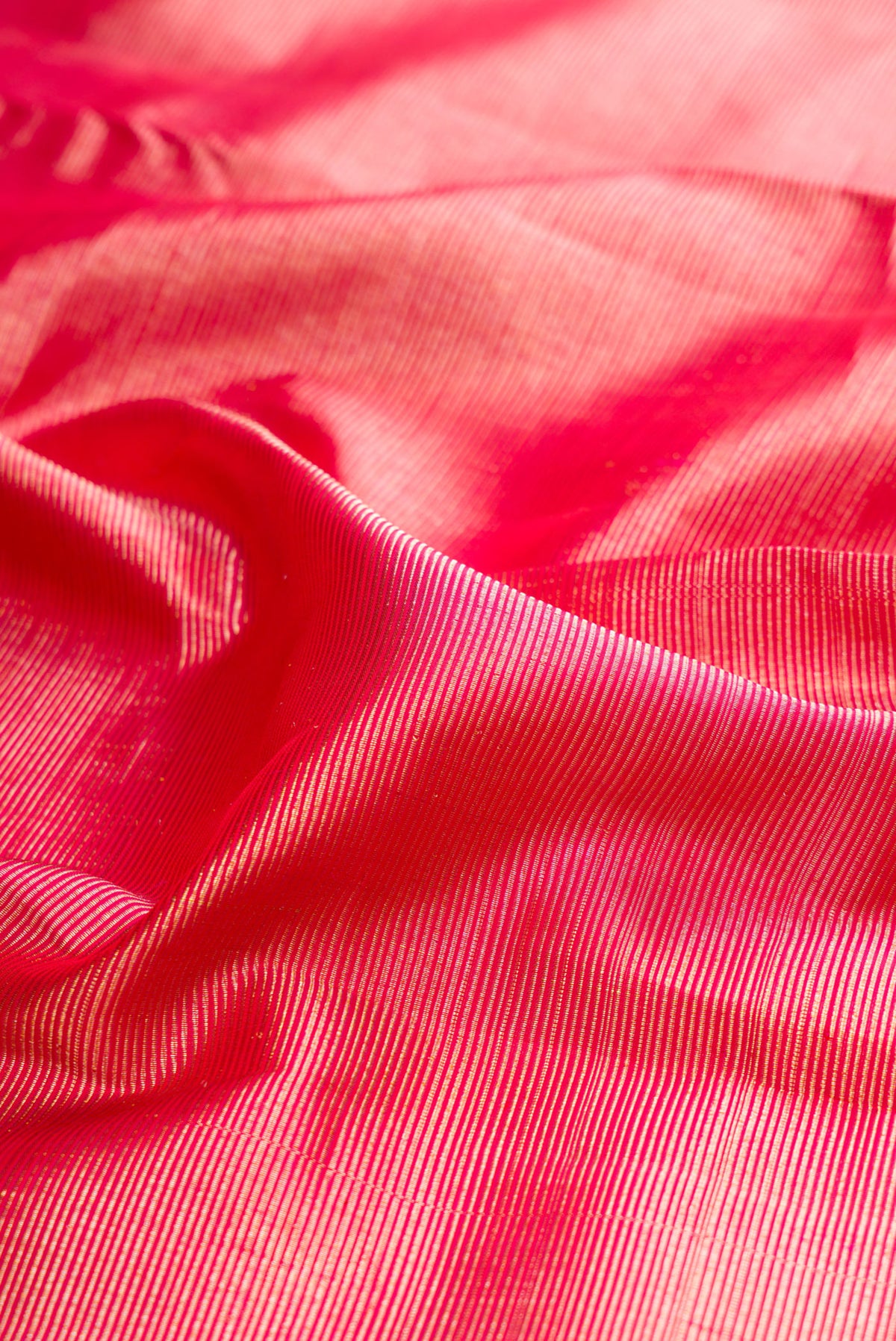 Close up of Pure Silk Pink Dual Tone Kanjivaram Saree with Zari Brocade on the body and Fancy Border.  displaying folds