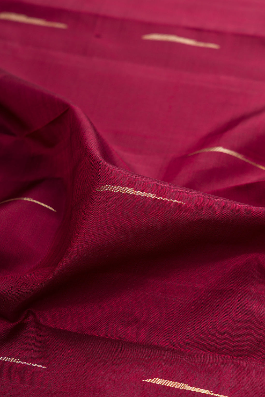 Close up of Pure Silk Maroon Kanjivaram Saree with Zari Butta on the body and Fancy Border.  displaying folds