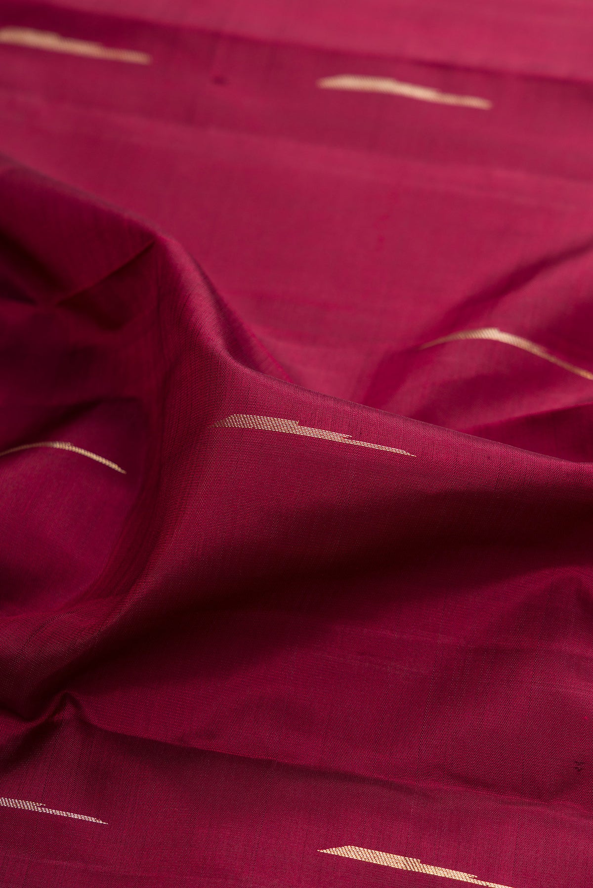 Close up of Pure Silk Maroon Kanjivaram Saree with Zari Butta on the body and Fancy Border.  displaying folds