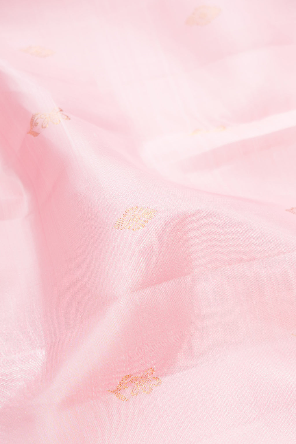 Close up of Pure Silk Rose pink Kanjivaram Saree with Zari Butta on the body and Zari Border.  displaying folds