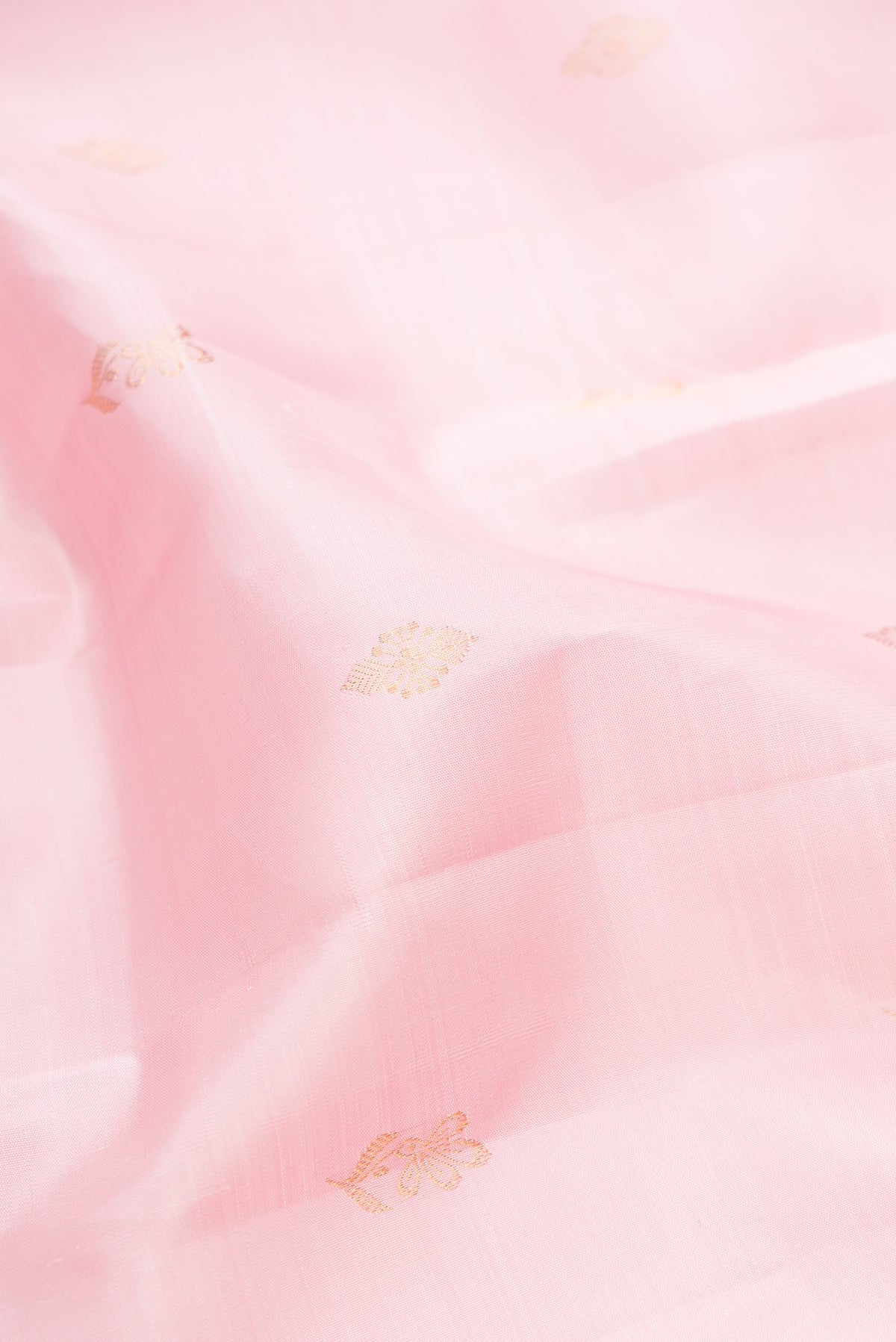 Close up of Pure Silk Rose pink Kanjivaram Saree with Zari Butta on the body and Zari Border.  displaying folds