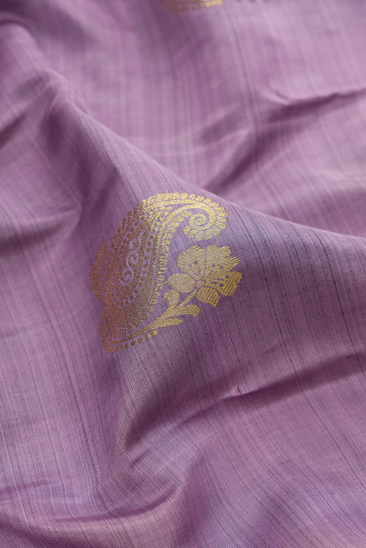 Close up of Pure Silk Lavender Kanchipuram Saree with Zari Butta on the body and Zari Border.  displaying folds
