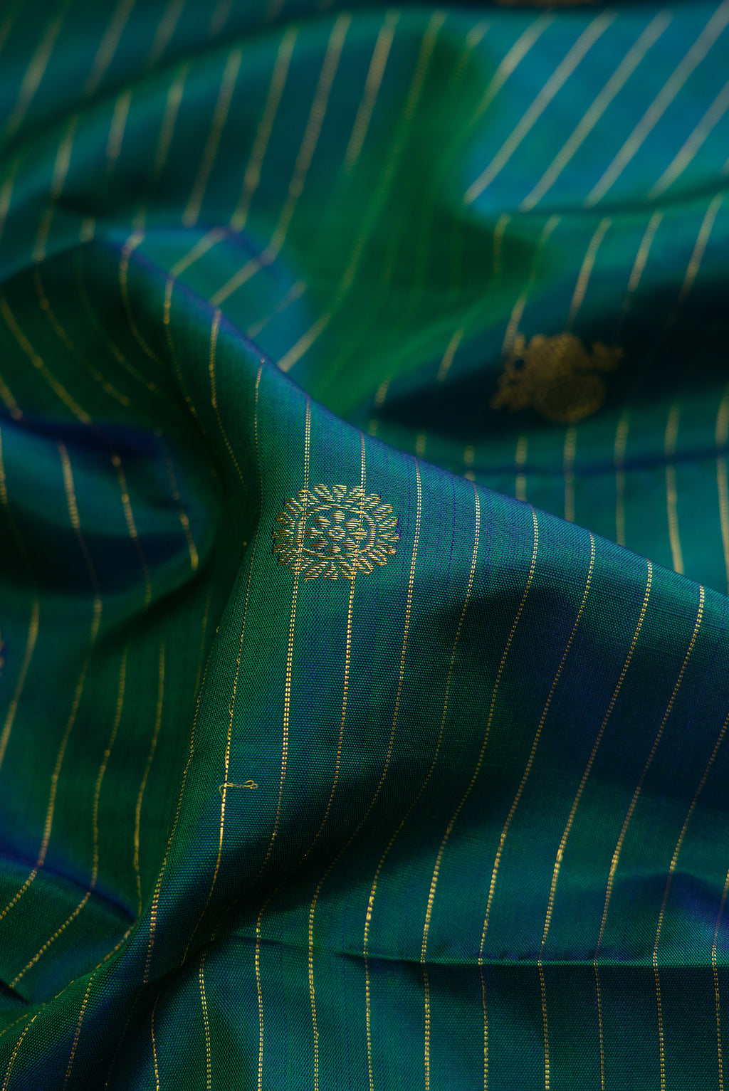 Close up of Pure Silk Green Dual Tone Kanchipuram Saree with Zari Butta on the body and Zari Border.  displaying folds