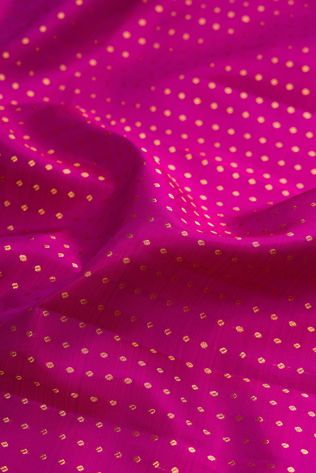 Close up of Pure Silk Magenta Kanchipuram Saree with Zari Butta on the body and Zari Border.  displaying folds