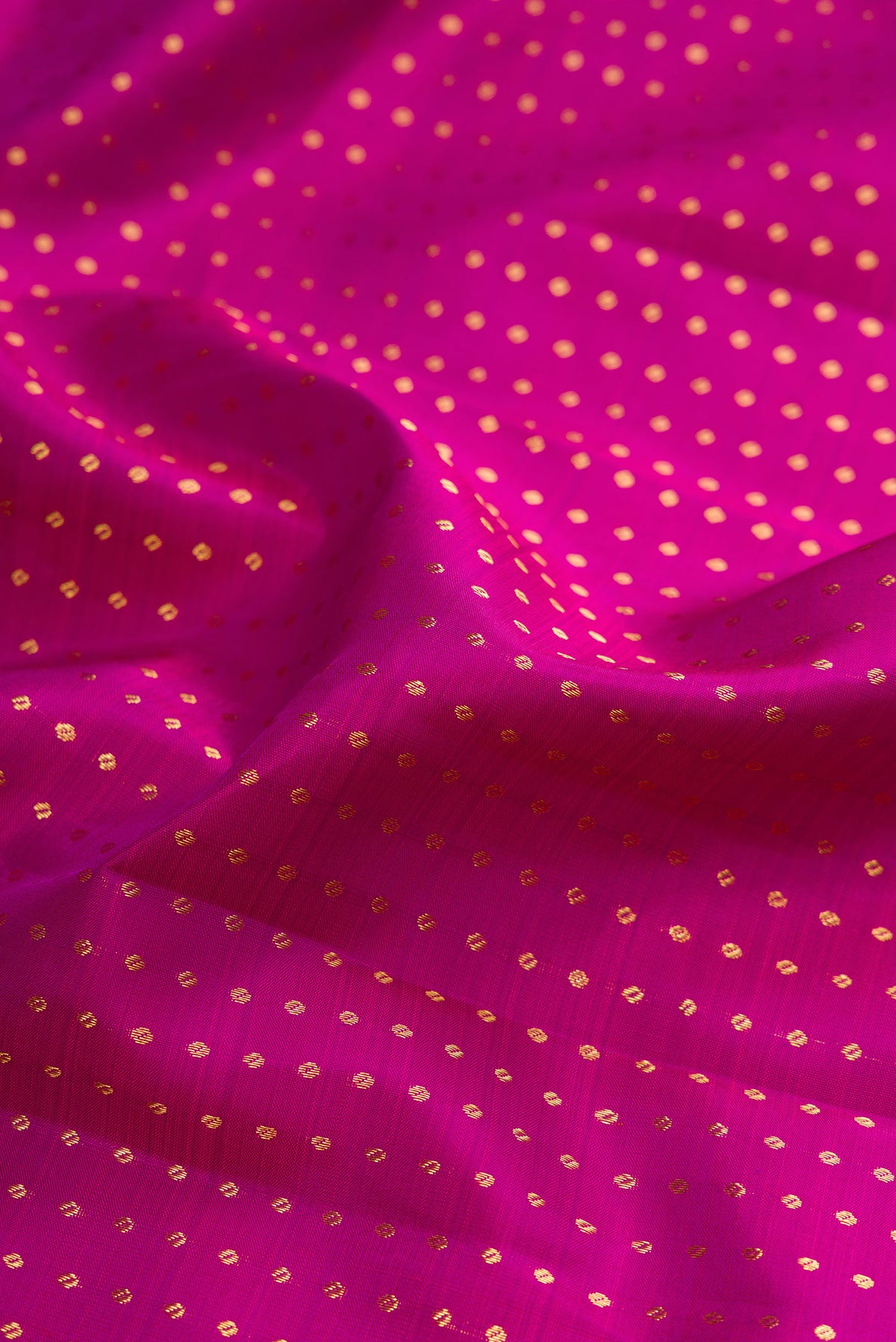 Close up of Pure Silk Magenta Kanchipuram Saree with Zari Butta on the body and Zari Border.  displaying folds