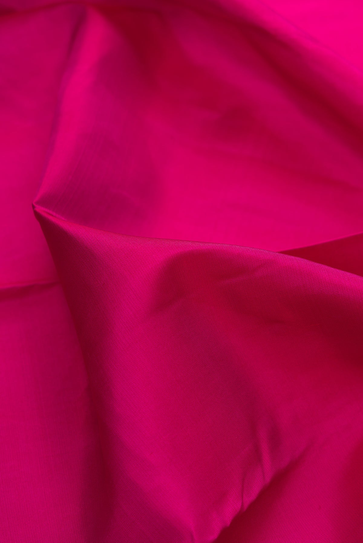 Close up of Pure Silk Dark Pink Kanchipuram Saree with Plain Body and Thread Border.  displaying folds
