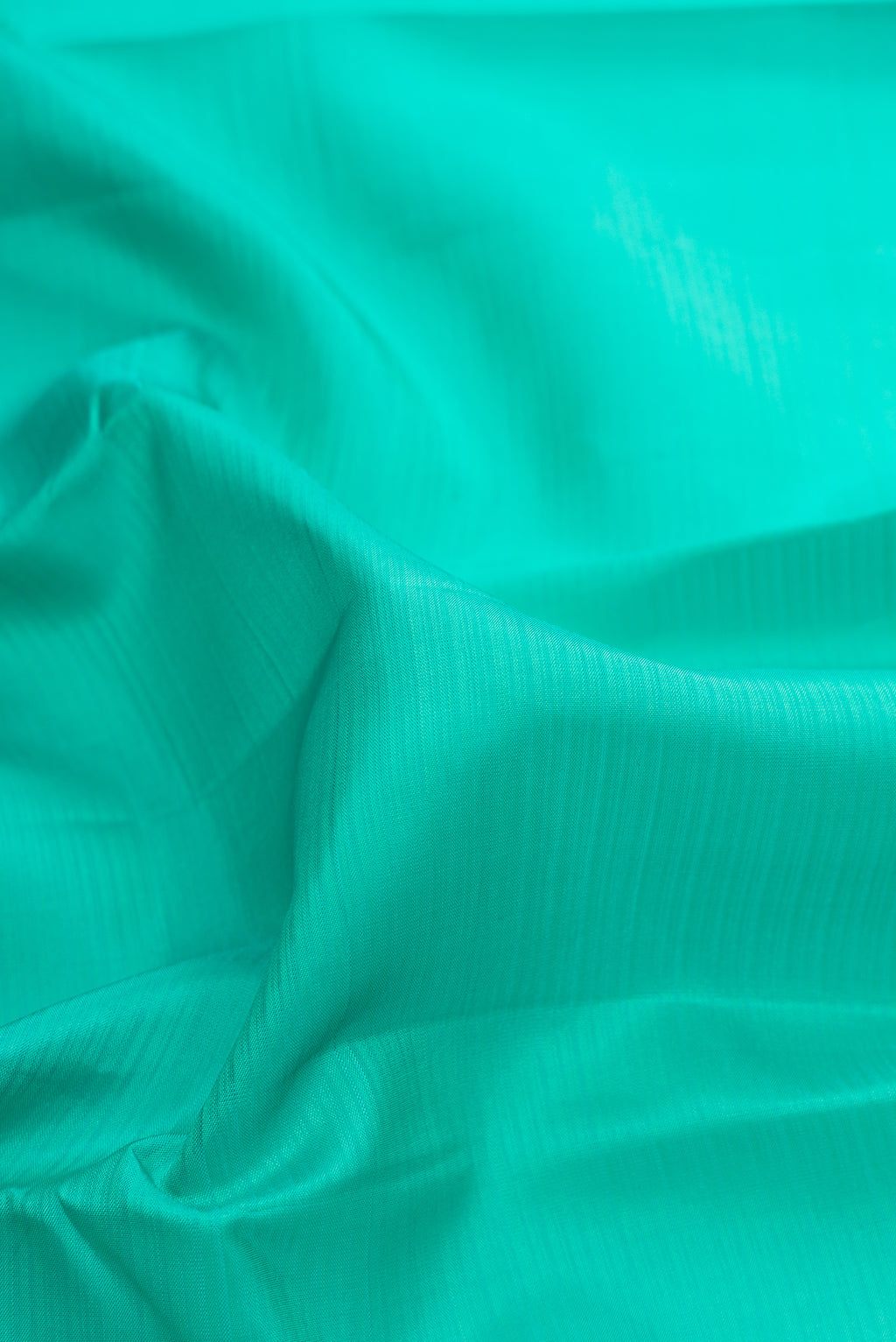 Close up of Pure Silk Sea Green Kanjivaram Saree with Stripes on the body and Thread Border.  displaying folds