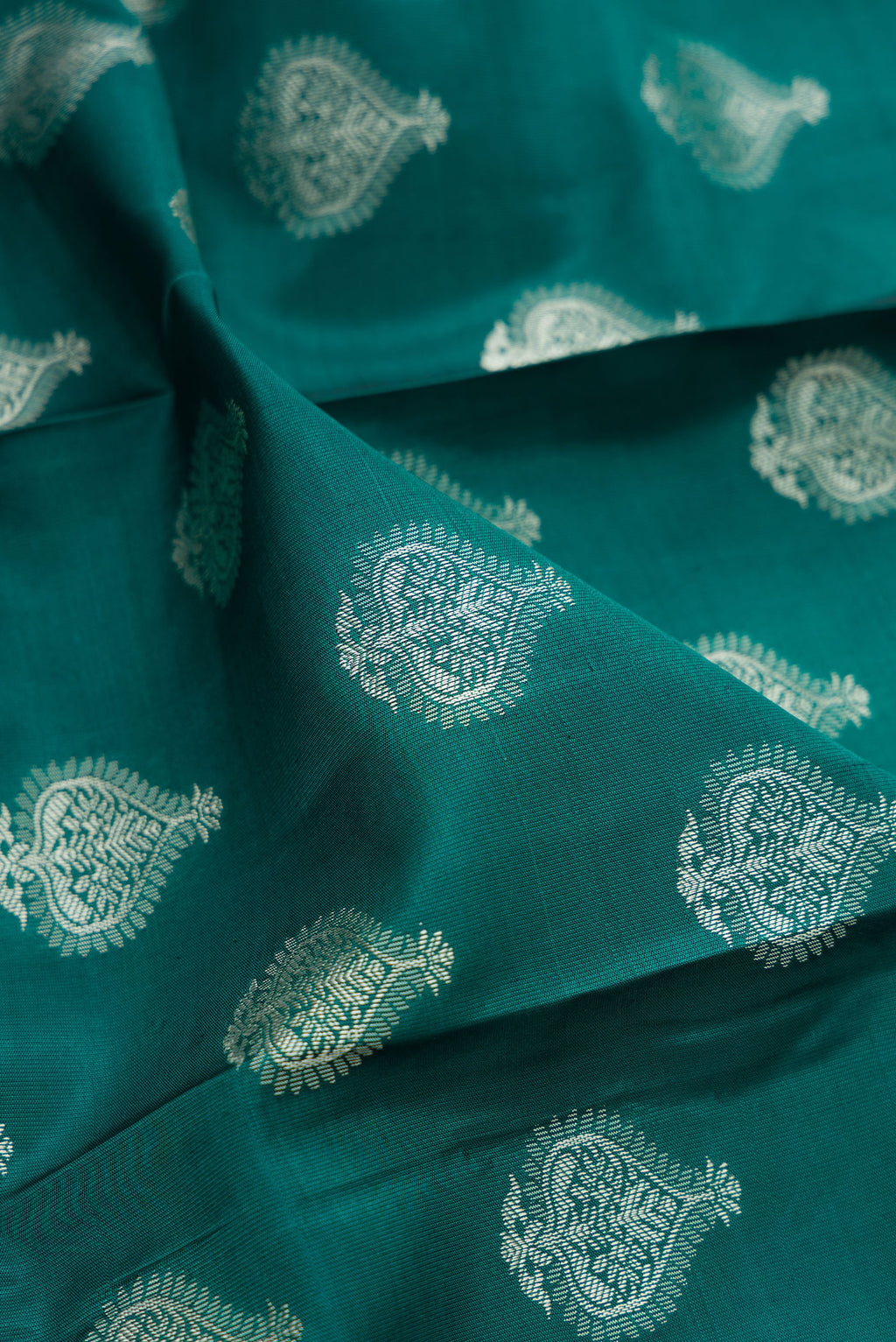 Close up of Pure Silk Green Dual Tone Kanchipuram Saree with Thread Butta on the body and Thread Border.  displaying folds