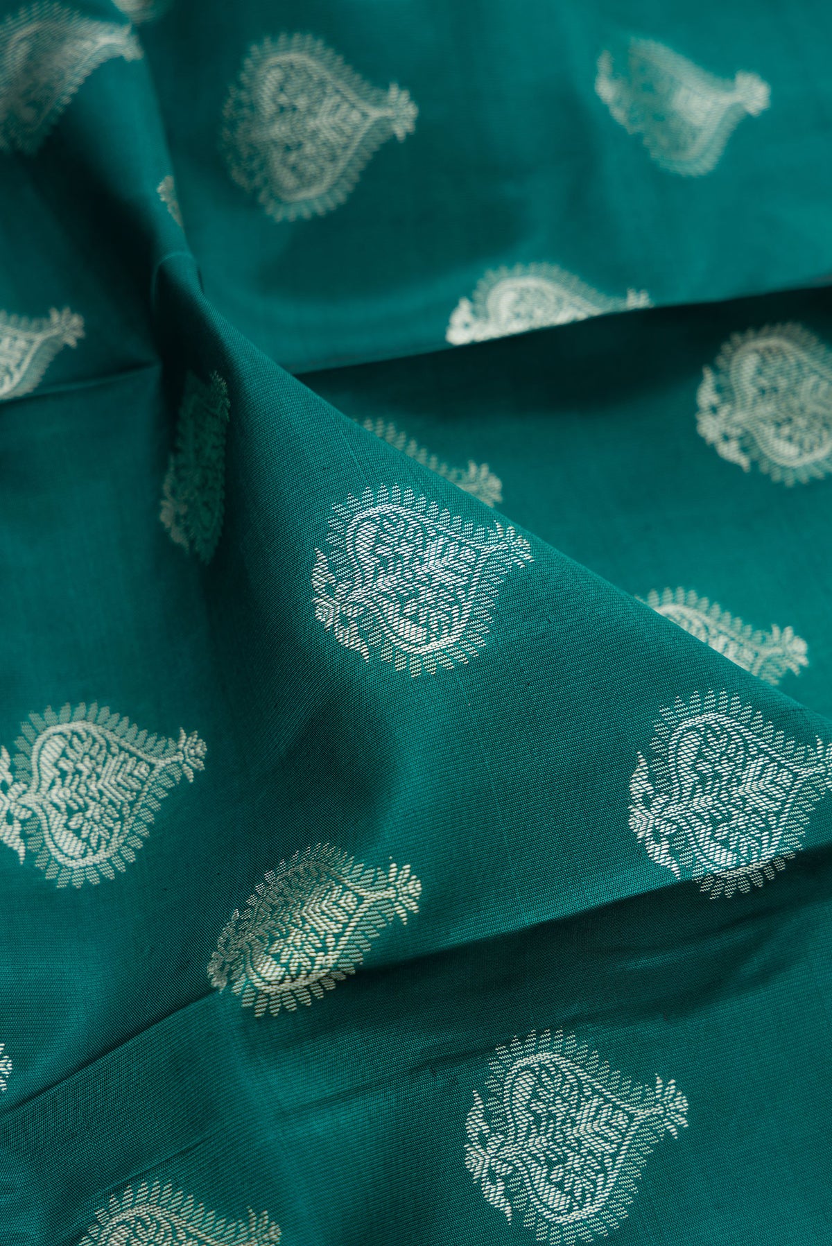Close up of Pure Silk Green Dual Tone Kanchipuram Saree with Thread Butta on the body and Thread Border.  displaying folds