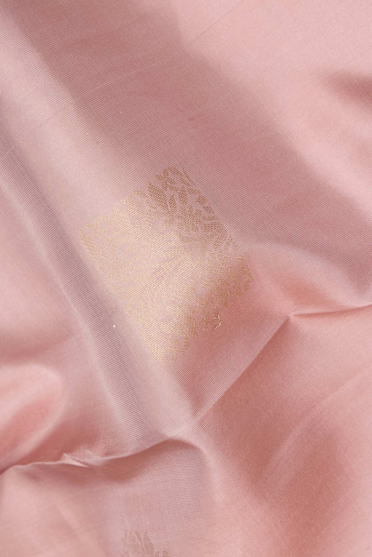 Close up of Pure Silk Rose Gold Kanchipuram Saree with Zari Butta on the body and Zari Border.  displaying folds