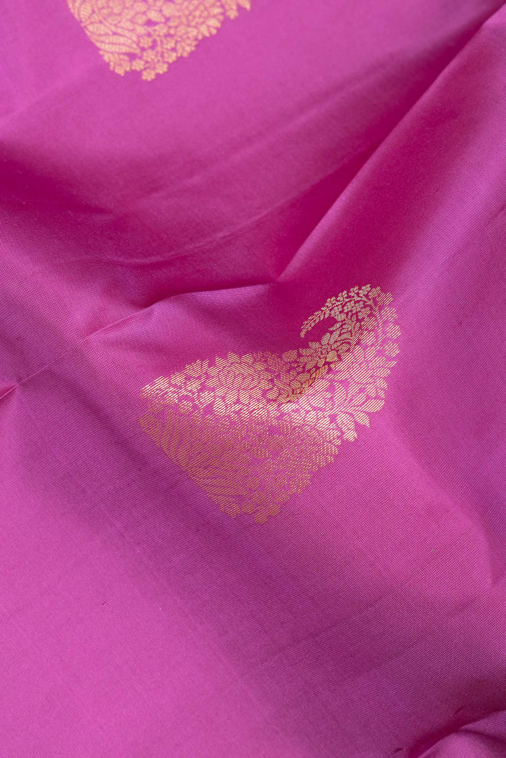 Close up of Pure Silk Pink Kanchipuram Saree with Zari Butta on the body and Fancy Border.  displaying folds