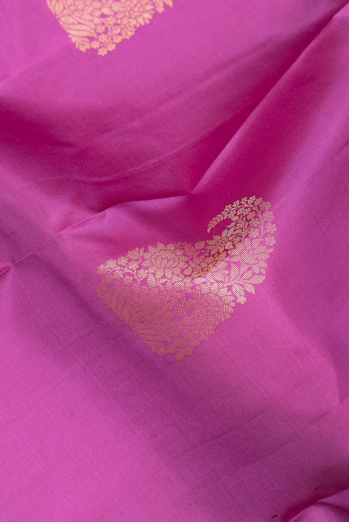Close up of Pure Silk Pink Kanchipuram Saree with Zari Butta on the body and Fancy Border.  displaying folds