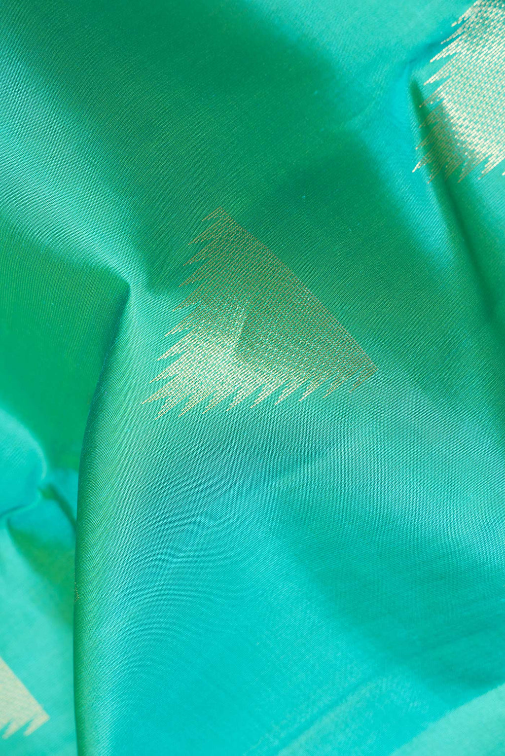 Close up of Pure Silk Sea Green Kanchipuram Saree with Zari Butta on the body and Zari Border.  displaying folds
