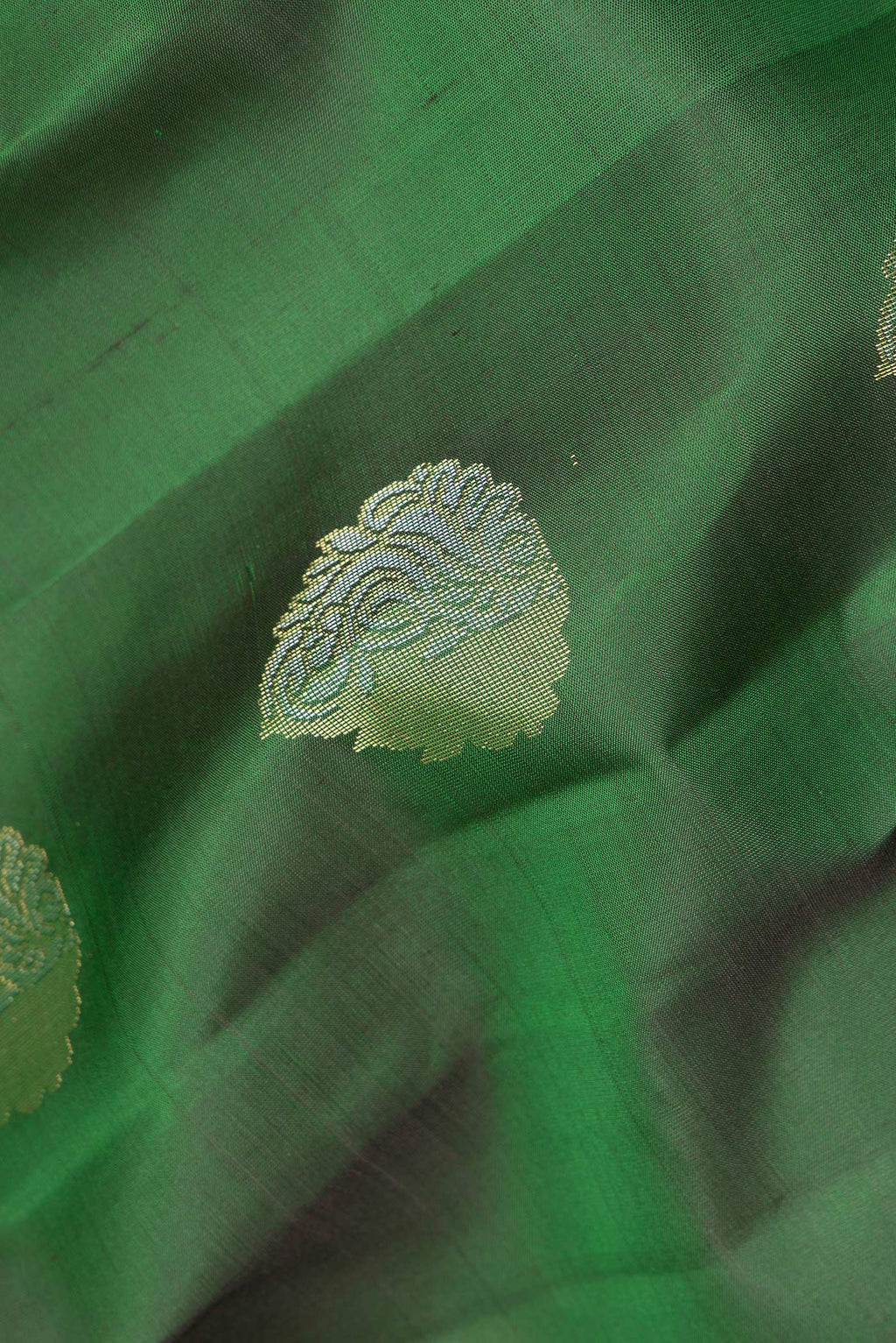 Close up of Pure Silk Green Kanchipuram Saree with Zari Butta on the body and Zari Border.  displaying folds