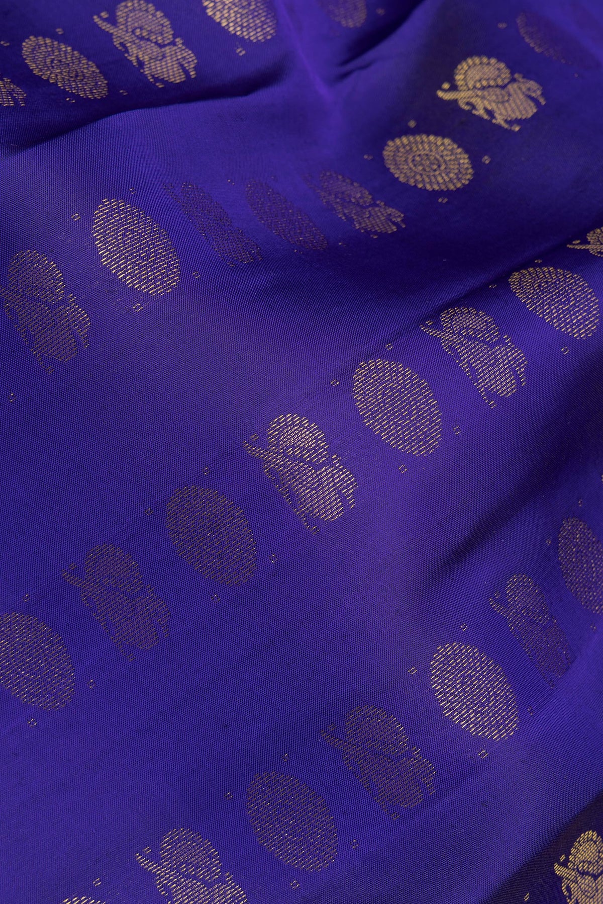 Close up of Pure Silk Dark Blue Kanchipuram Saree with Zari Butta on the body and Zari Border.  displaying folds