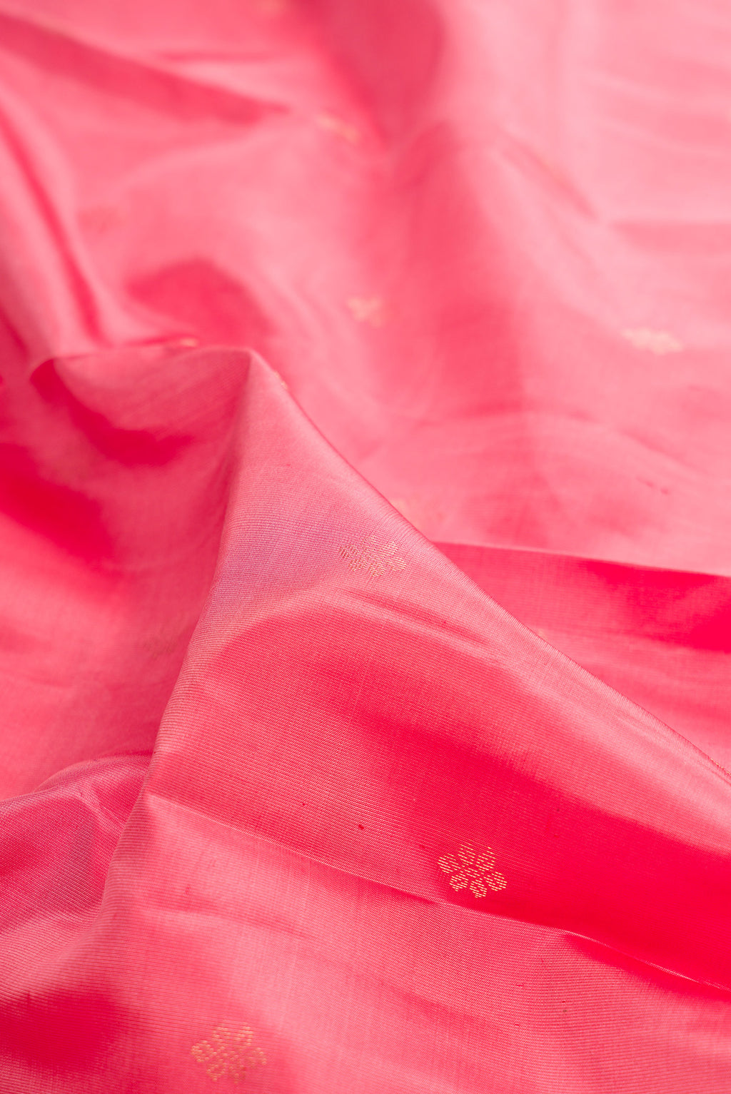Close up of Pure Silk Coral Kanchipuram Saree with Zari Butta on the body and Zari Border.  displaying folds