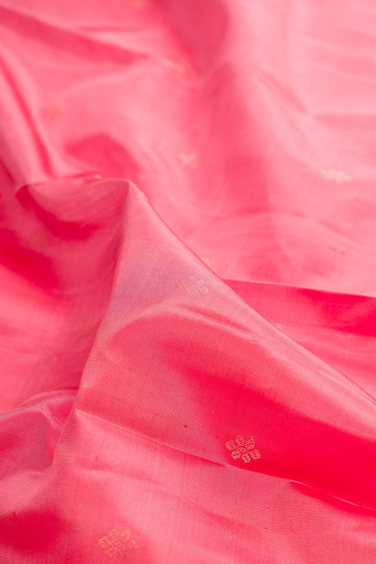 Close up of Pure Silk Coral Kanchipuram Saree with Zari Butta on the body and Zari Border.  displaying folds