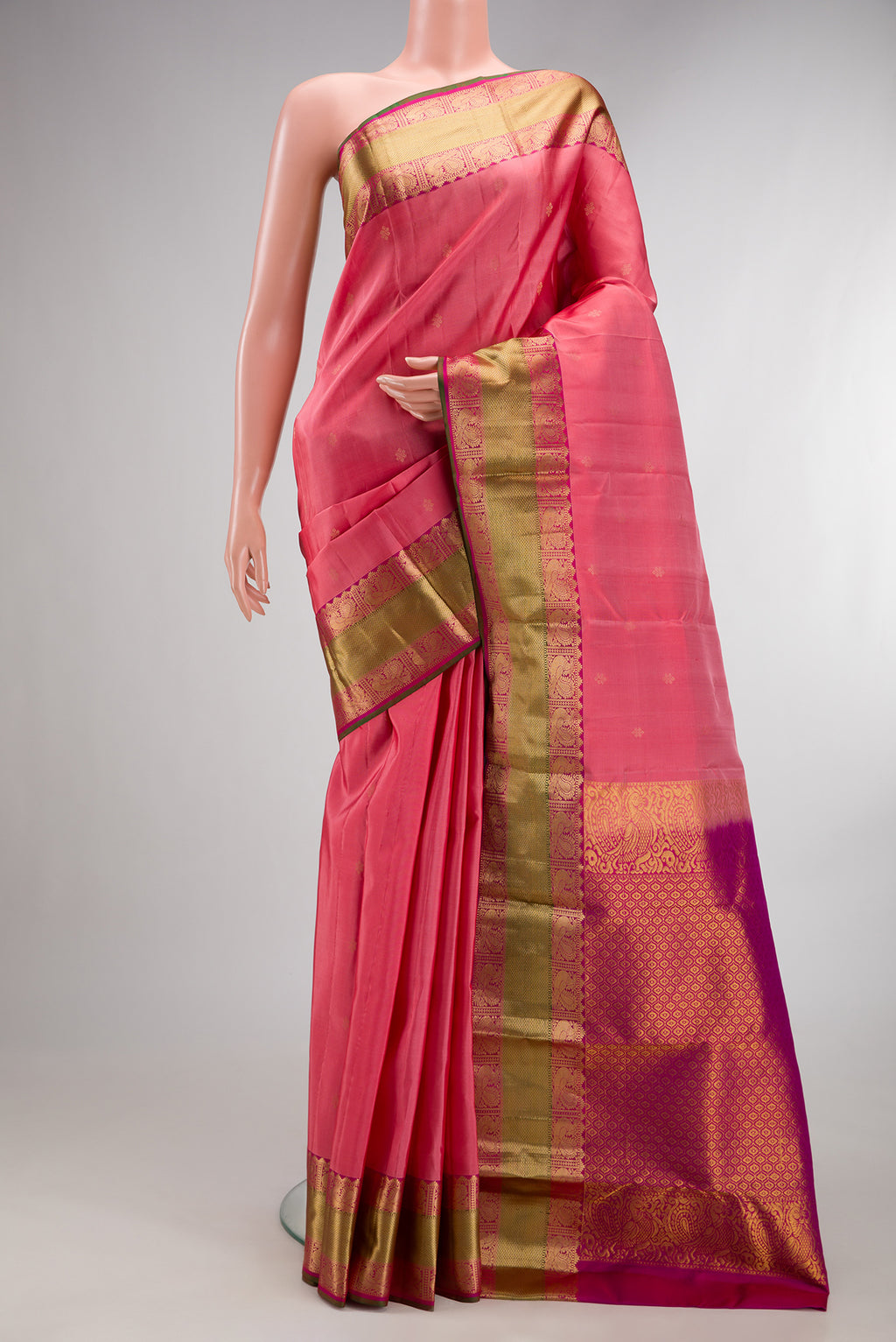 Pure Silk Coral Kanchipuram Saree with Zari Butta on the body and Zari Border.  displayed on a mannequin