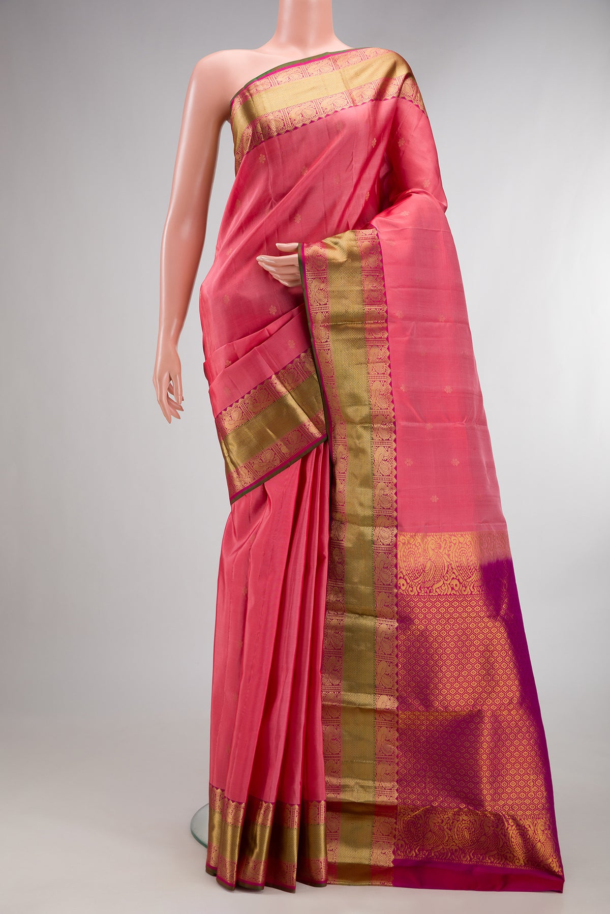 Pure Silk Coral Kanchipuram Saree with Zari Butta on the body and Zari Border.  displayed on a mannequin