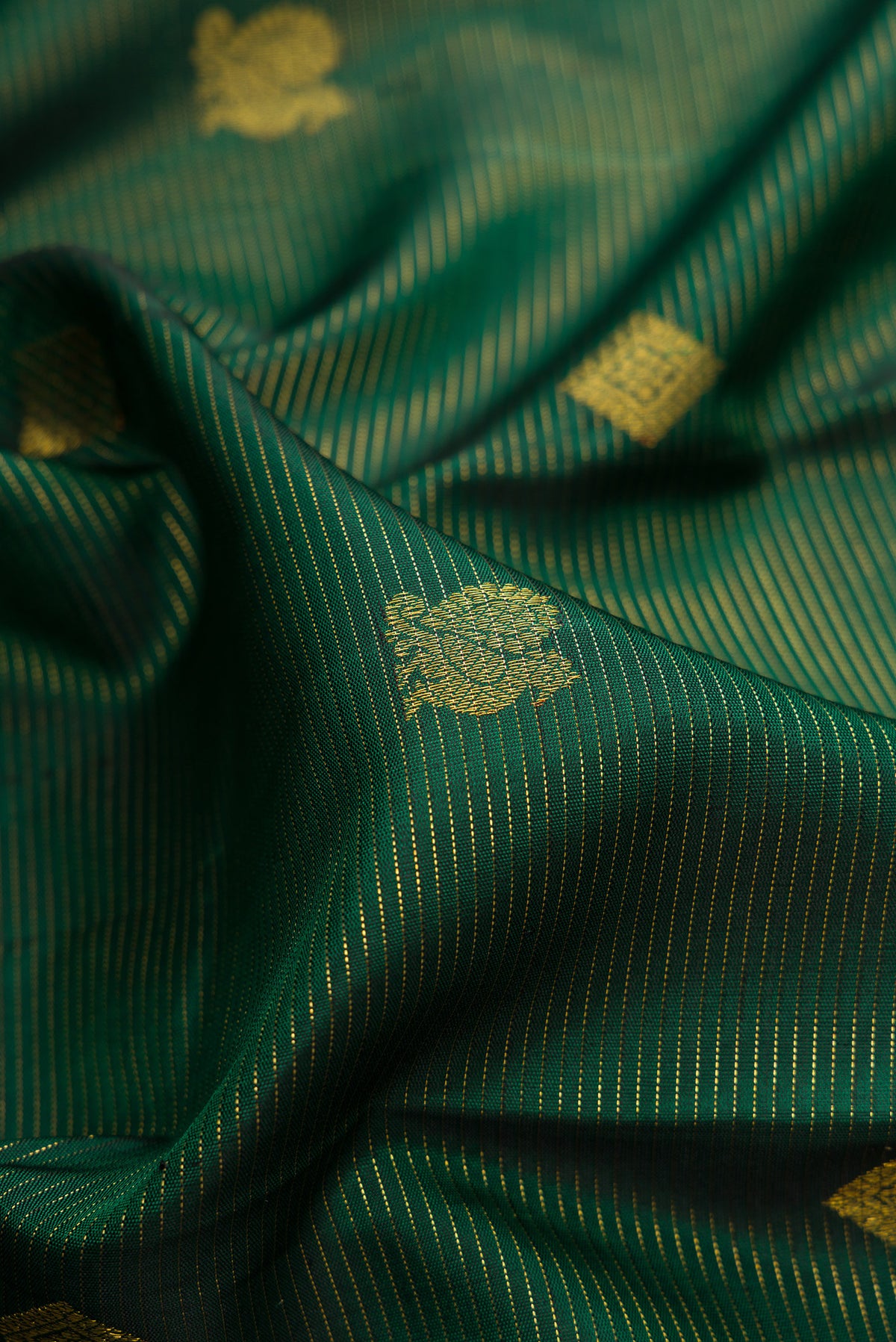 Close up of Pure Silk Bottle Green Kanjivaram Saree with Stripes on the body and Without Border.  displaying folds