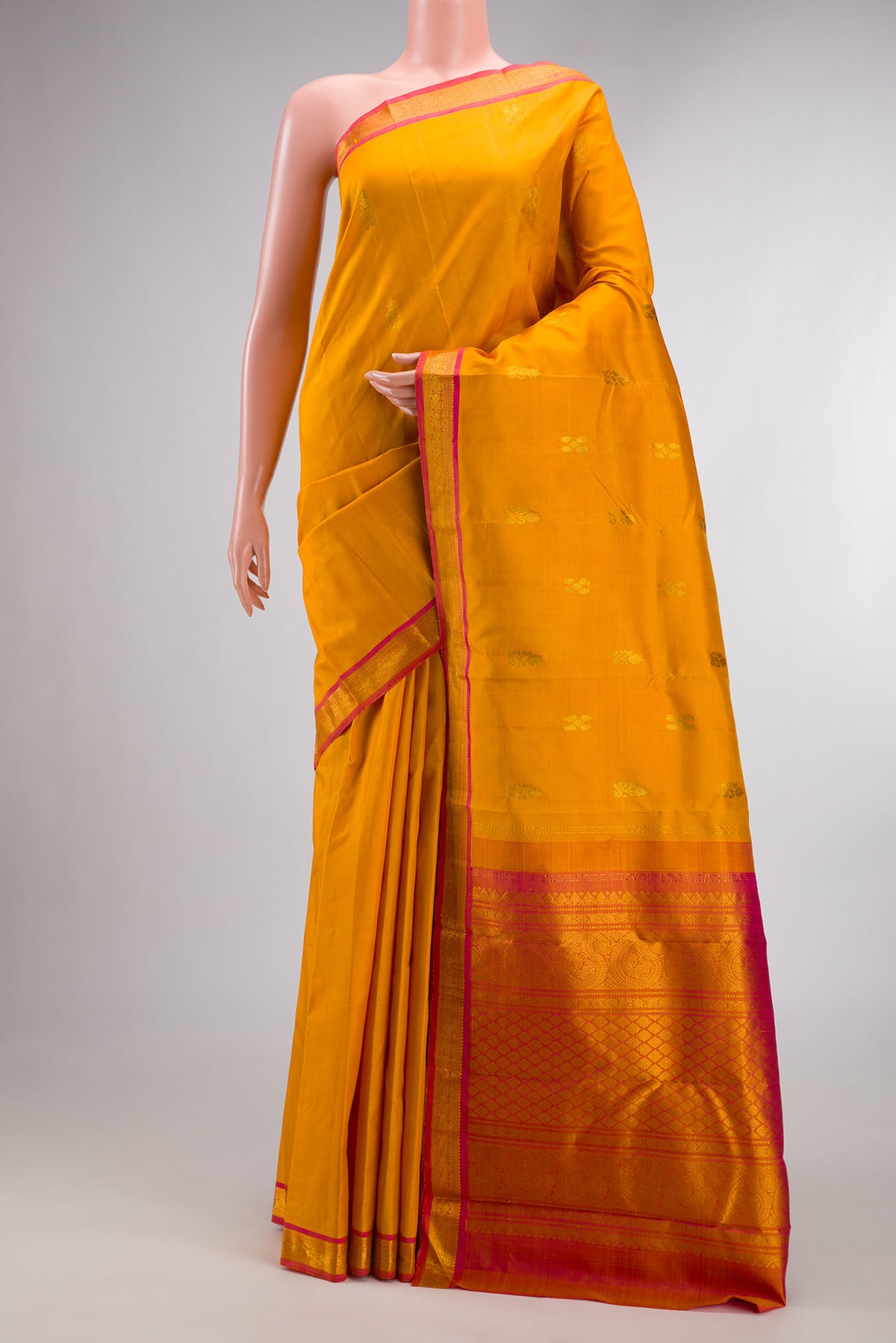 Pure Silk Mustard Kanchipuram Saree with Zari Butta on the body and Zari Border.  displayed on a mannequin