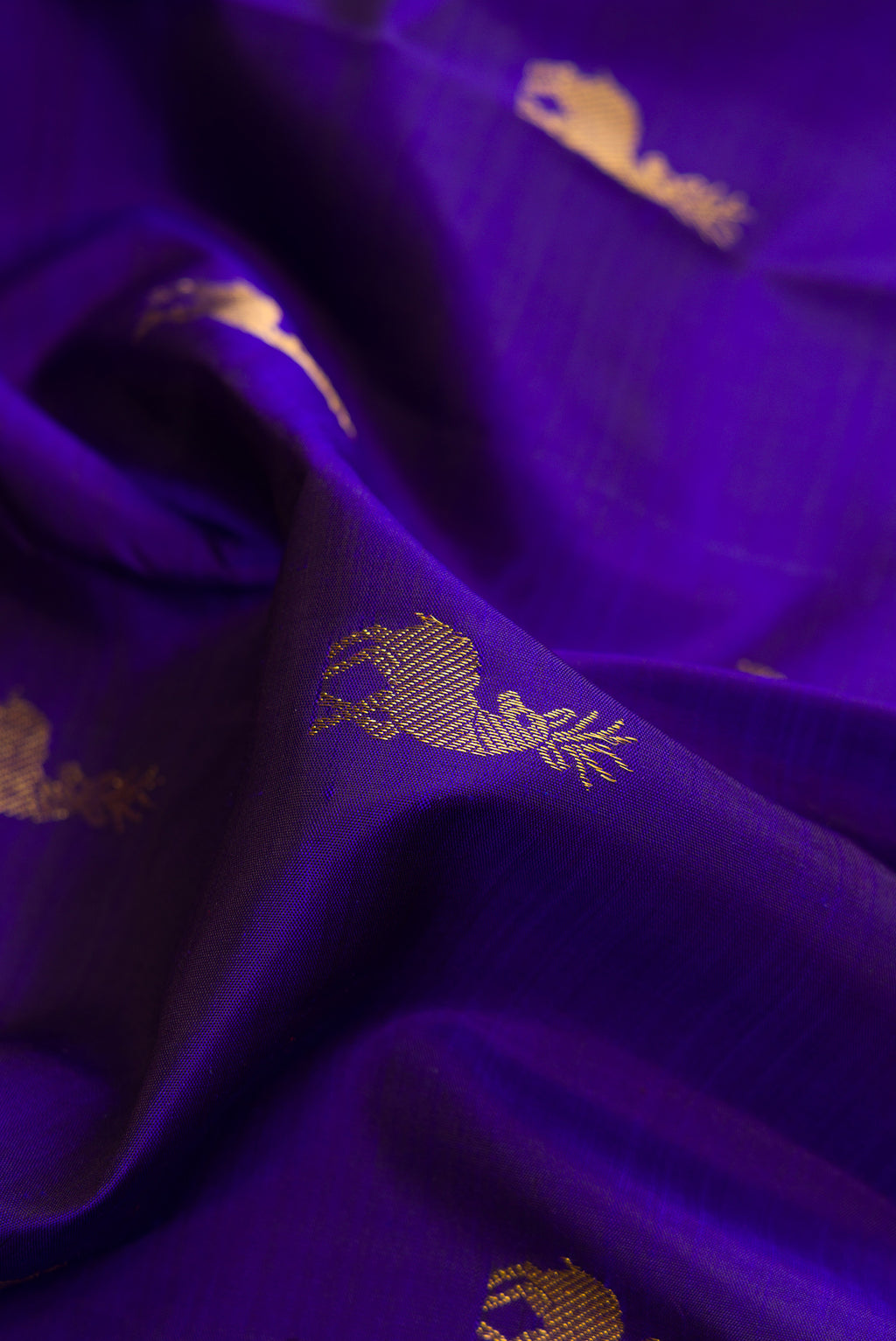 Close up of Pure Silk Royal Blue Kanjivaram Saree with Zari Butta on the body and Zari Border.  displaying folds