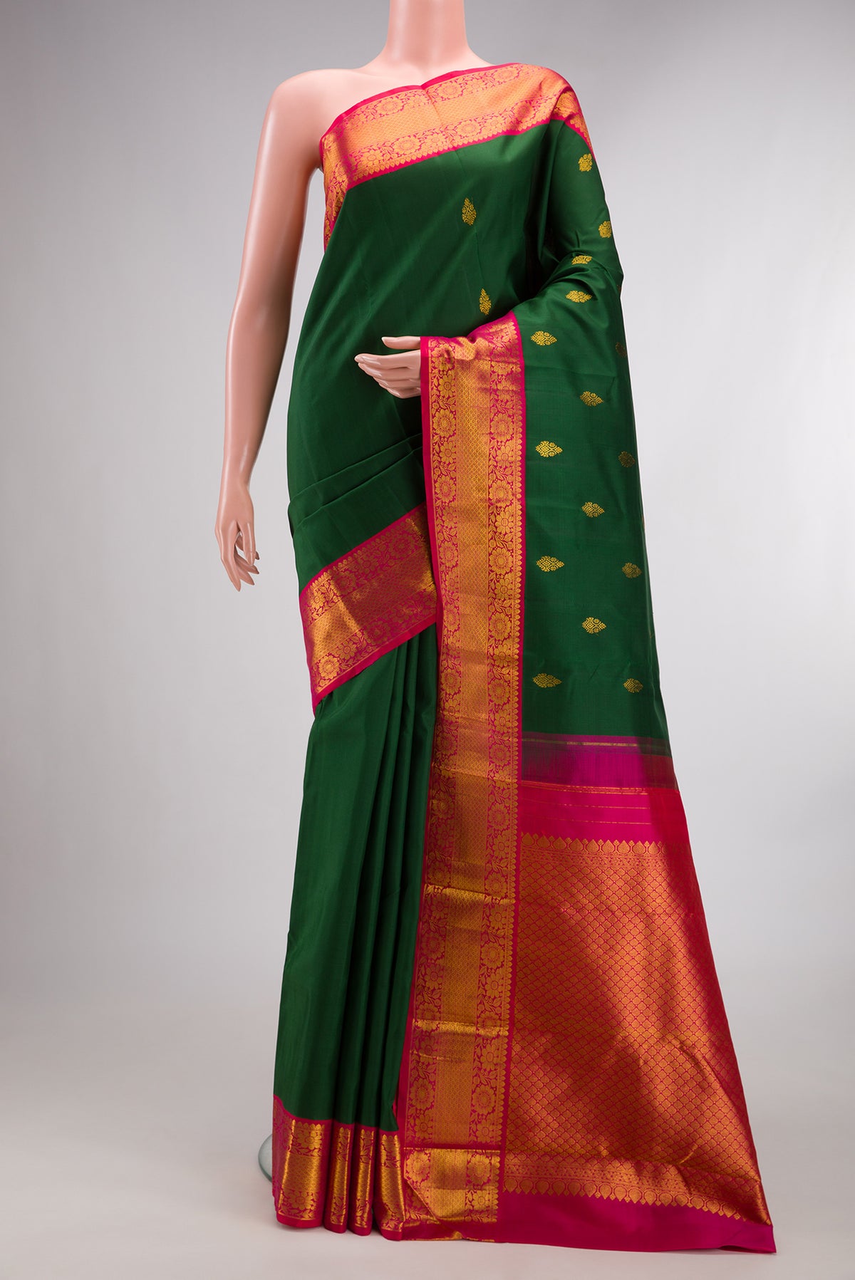 Pure Silk Bottle Green Kanjivaram Saree with Zari Butta on the body and Zari Border.  displayed on a mannequin