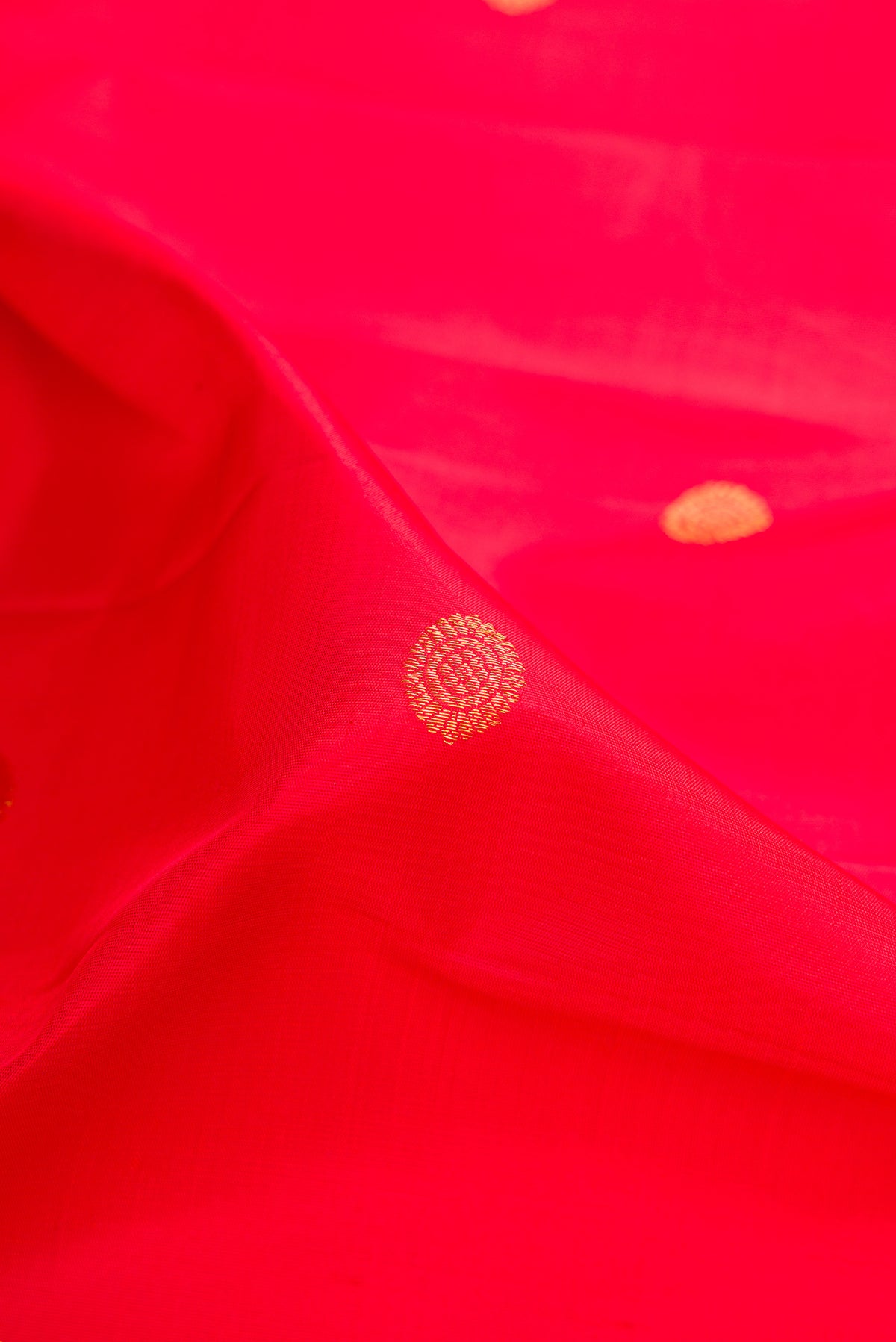 Close up of Pure Silk Red Dual Tone Kanjivaram Saree with Zari Butta on the body and Fancy Border.  displaying folds