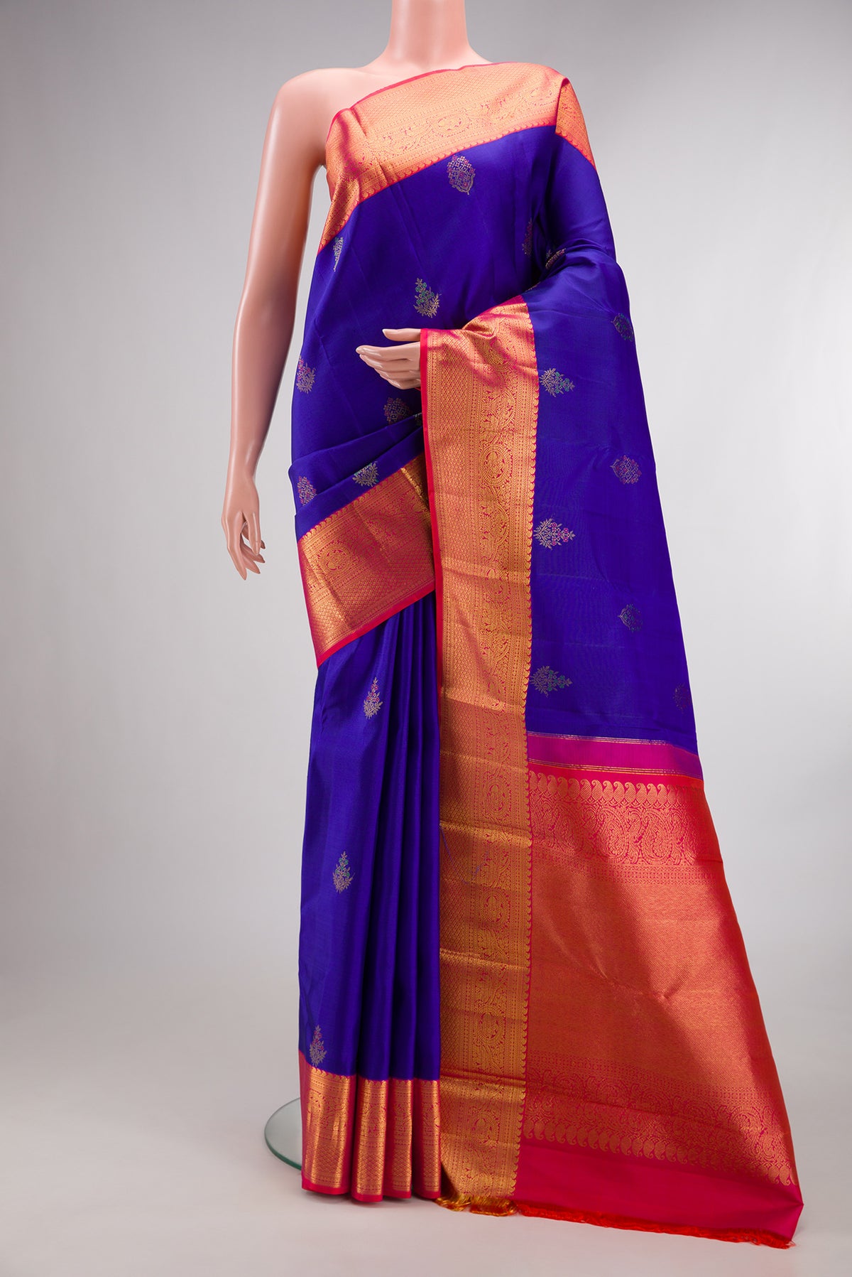 Pure Silk Royal Blue Kanjivaram Saree with Zari And Thread Butta on the body and Zari Border.  displayed on a mannequin