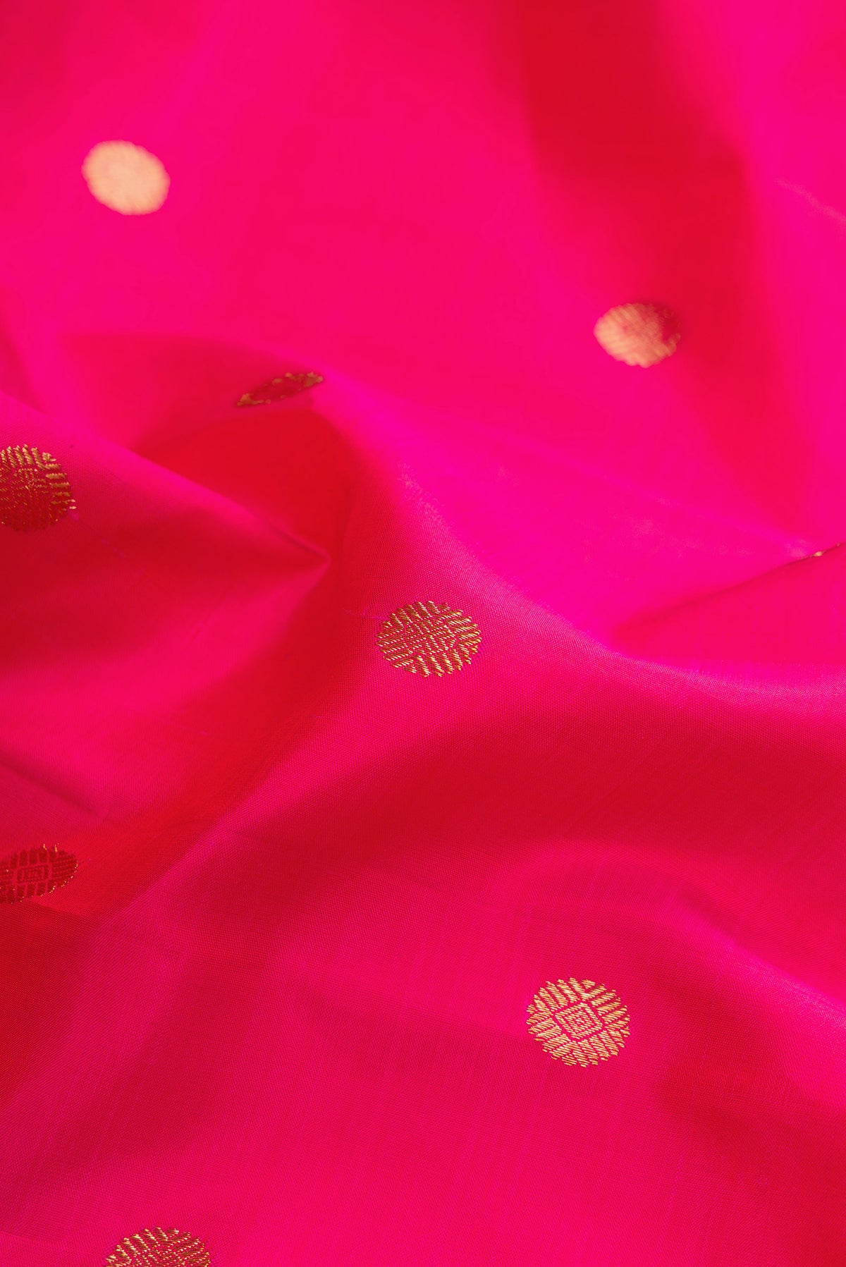 Close up of Pure Silk Coral Kanchipuram Saree with Zari Butta on the body and Zari Border.  displaying folds