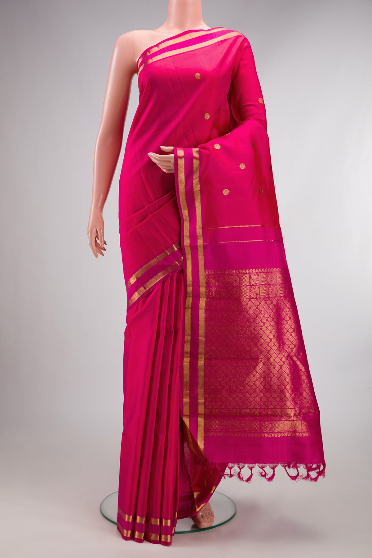 Pure Silk Coral Kanchipuram Saree with Zari Butta on the body and Zari Border.  displayed on a mannequin