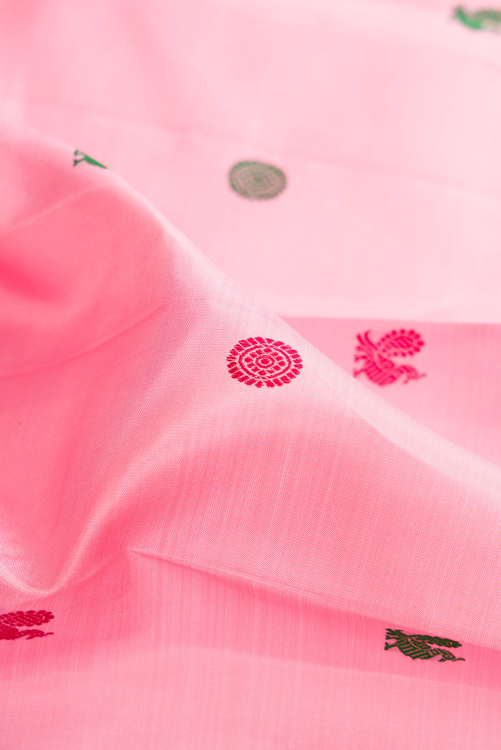 Close up of Pure Silk Rose pink Kanjivaram Saree with Thread Butta on the body and Zari Border.  displaying folds