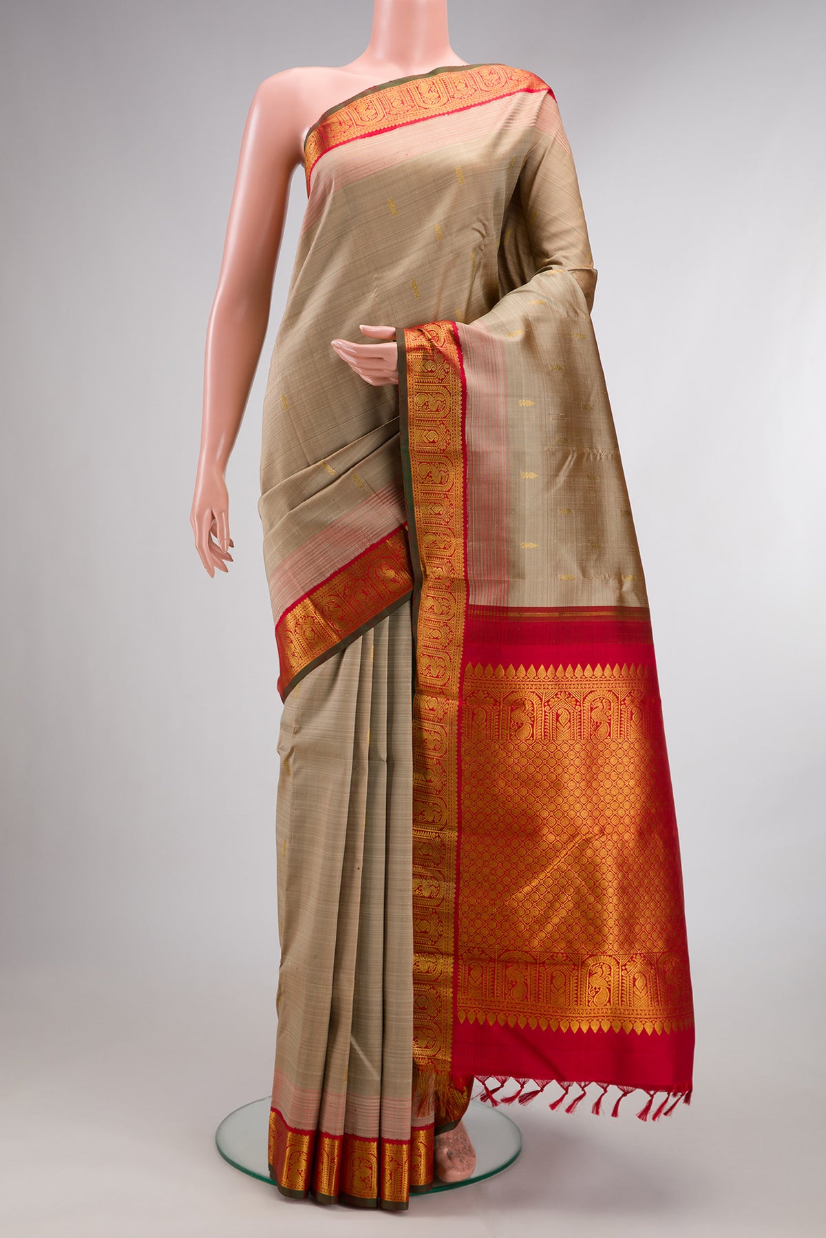 Pure Silk Dark Beige Kanjivaram Saree with Zari Butta on the body and Zari Border.  displayed on a mannequin