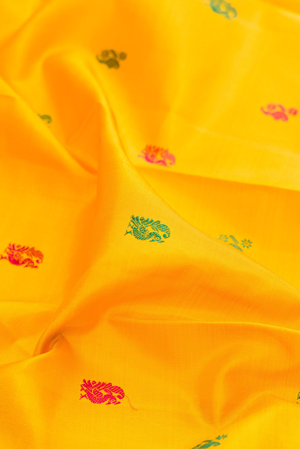 Close up of Pure Silk Mustard Kanjivaram Saree with Thread Butta on the body and Zari Border.  displaying folds