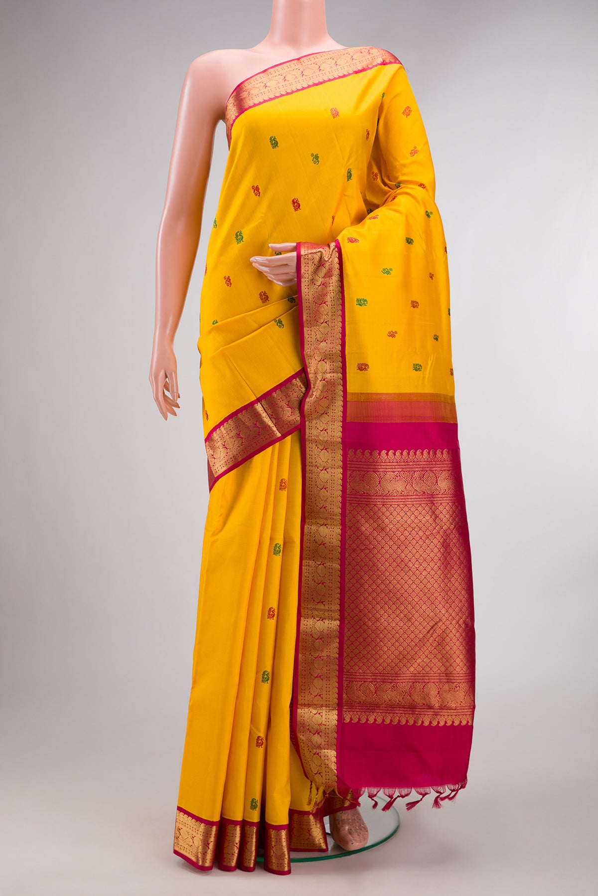 Pure Silk Mustard Kanjivaram Saree with Thread Butta on the body and Zari Border.  displayed on a mannequin