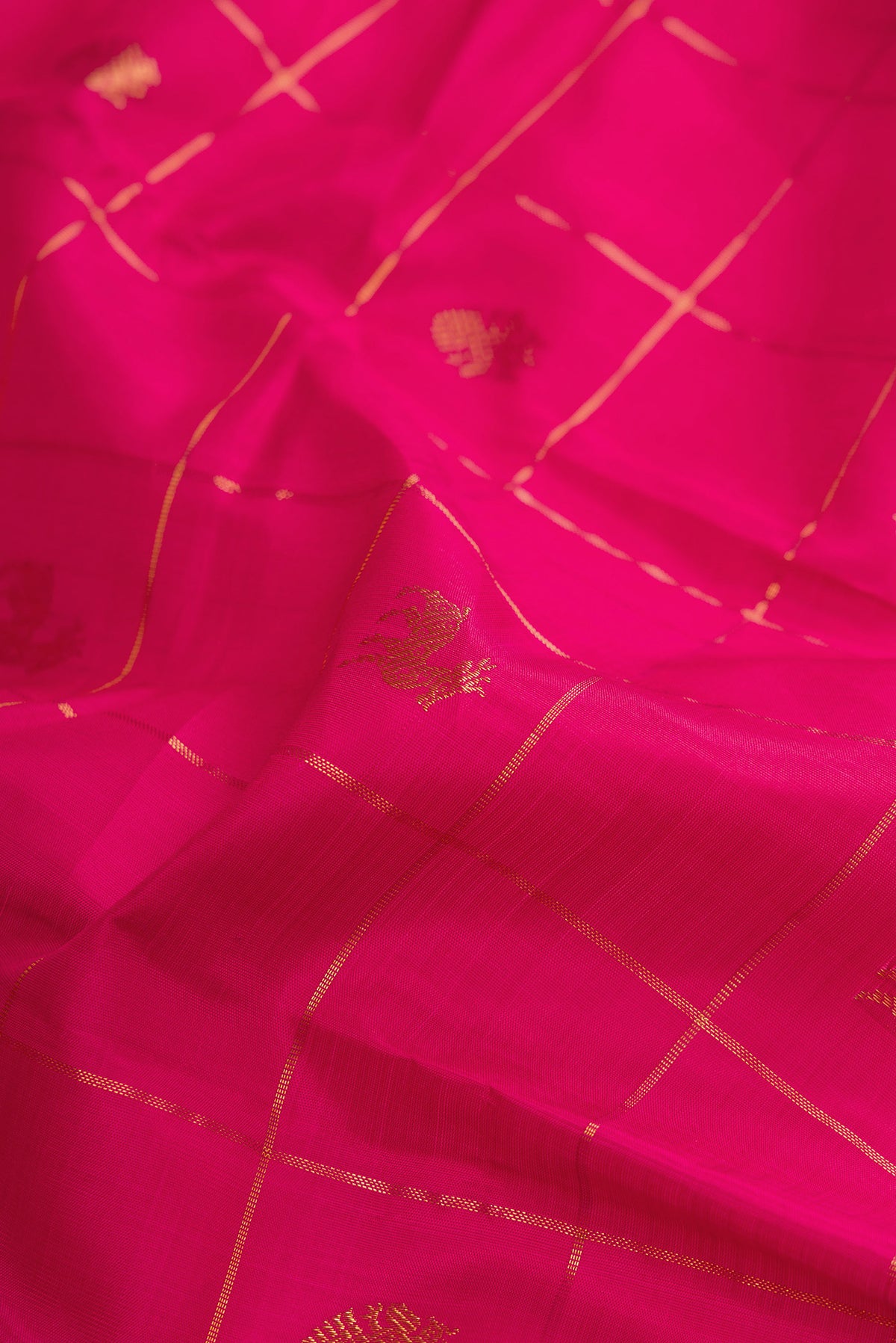 Close up of Pure Silk Dark Pink Kanjivaram Saree with Checked design on the body and Zari Border.  displaying folds