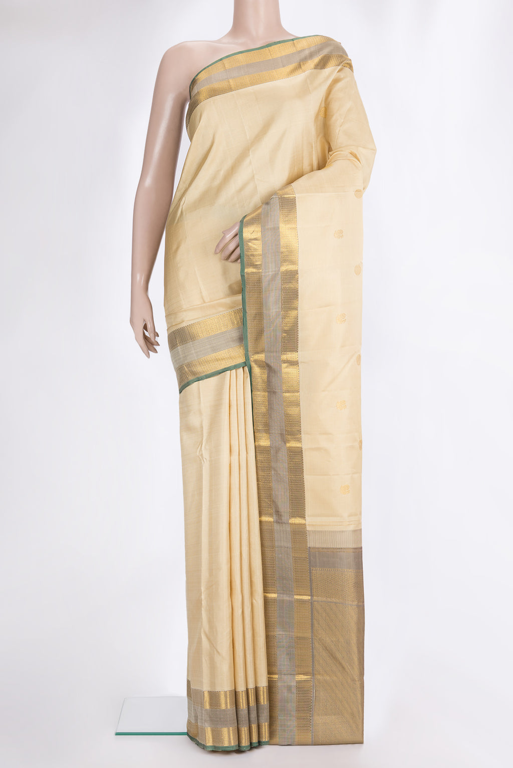 Pure Silk Beige Kanjivaram Saree with Zari Butta on the body and Zari Border.  displayed on a mannequin
