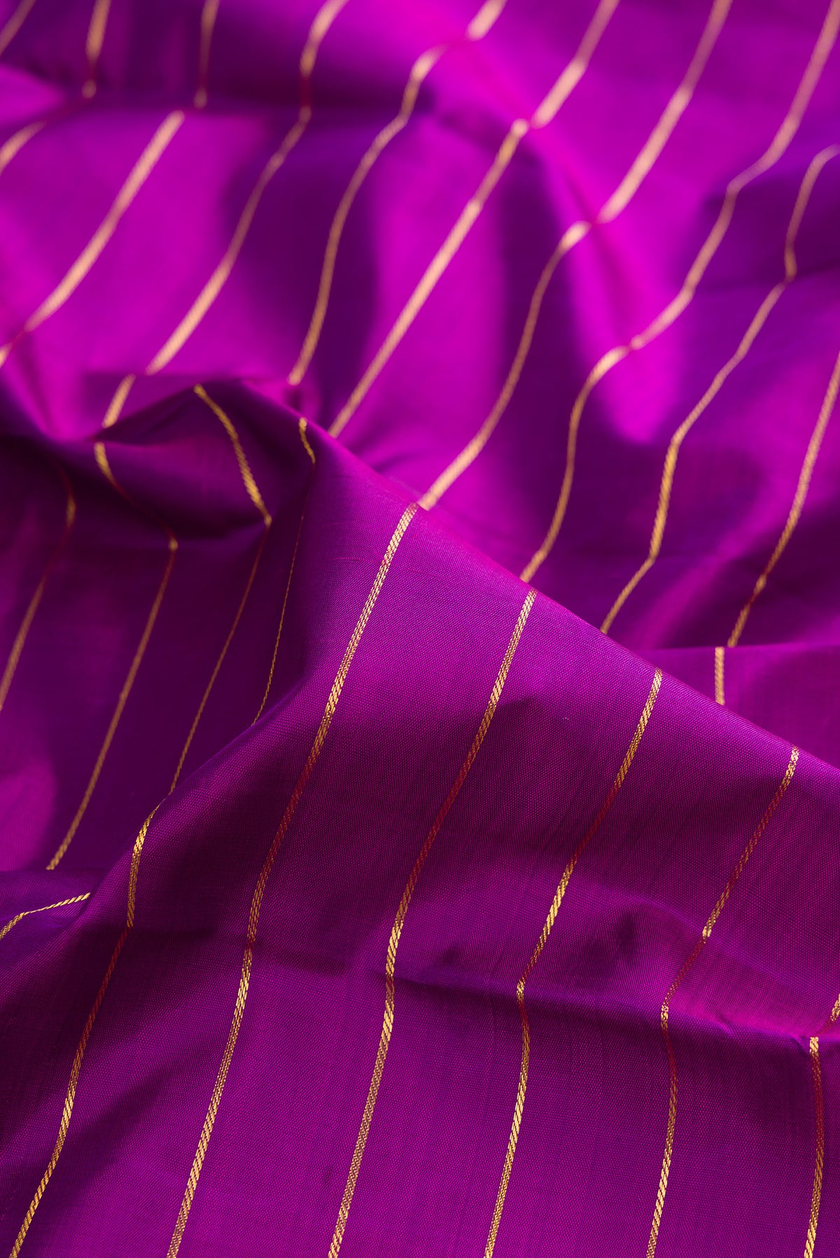 Close up of Pure Silk Purple Kanjivaram Saree with Veldhari on the body and Zari Border.  displaying folds