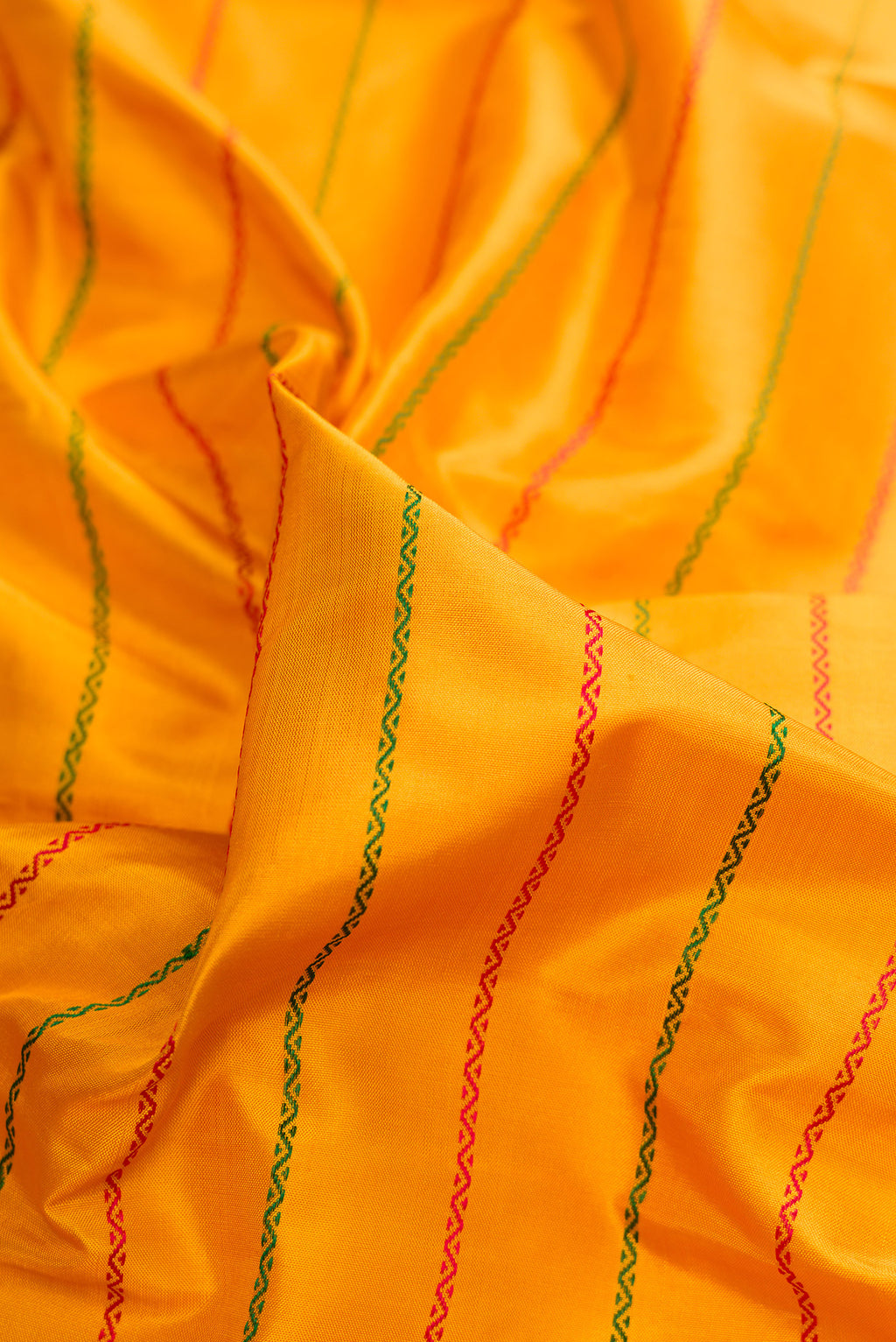 Close up of Pure Silk Mustard Kanjivaram Saree with Veldhari on the body and Zari Border.  displaying folds