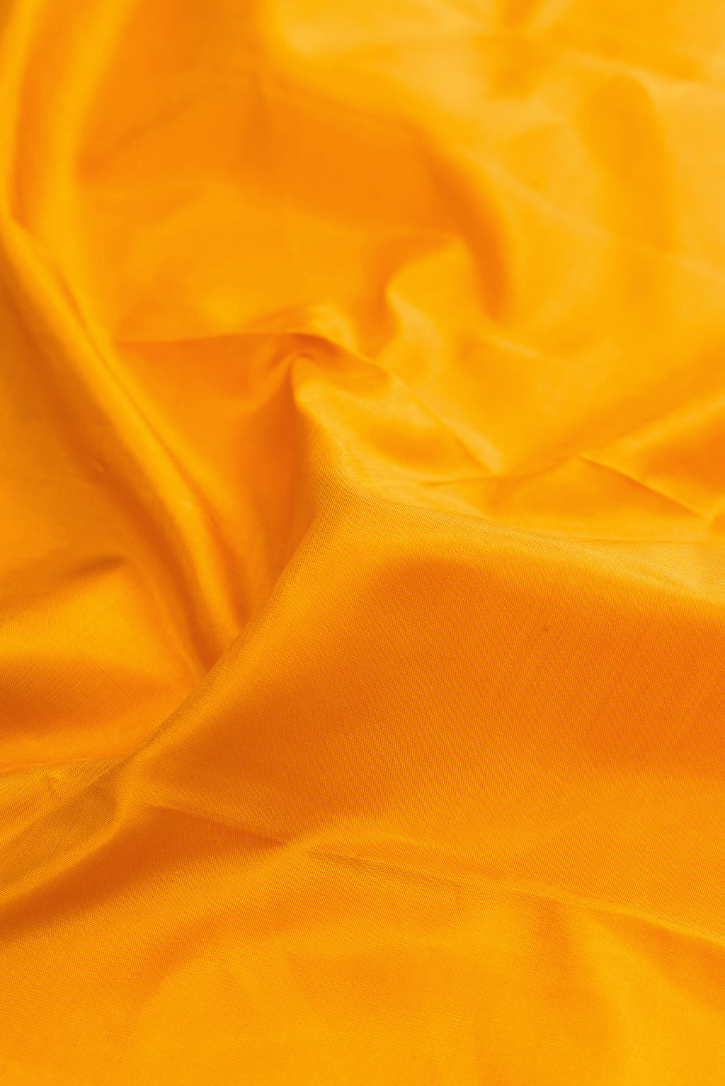 Close up of Pure Silk Mustard Kanjivaram Saree with Plain Body and Zari Border.  displaying folds