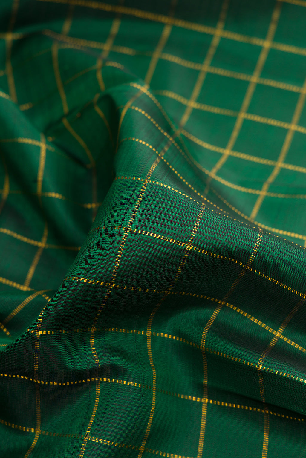 Close up of Pure Silk Bottle Green Kanchipuram Saree with Checked design on the body and Zari Border.  displaying folds