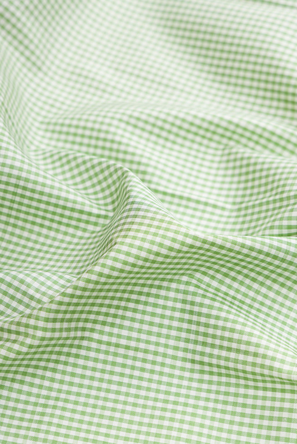 Close up of Pure Silk Pista Green Dual Tone Kanjivaram Saree with Checked design on the body and Temple Border.  displaying folds
