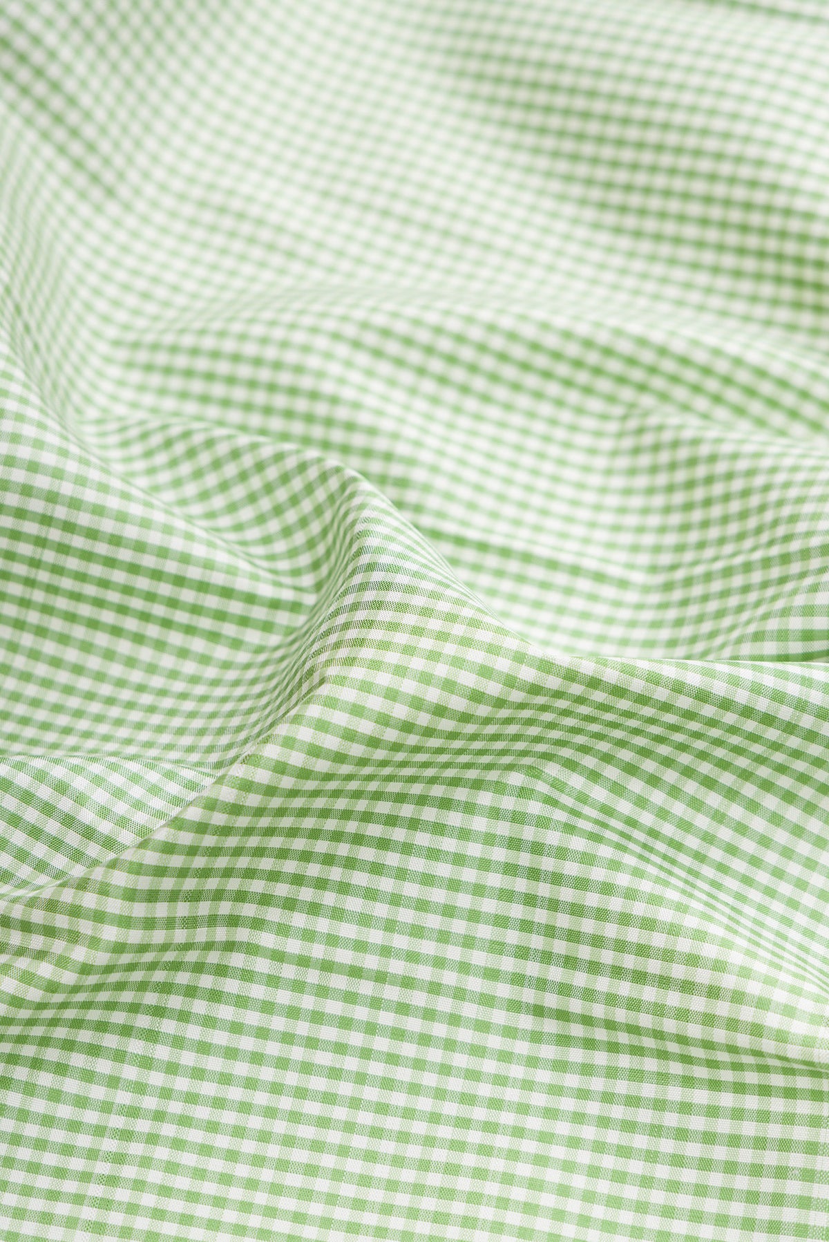 Close up of Pure Silk Pista Green Dual Tone Kanjivaram Saree with Checked design on the body and Temple Border.  displaying folds