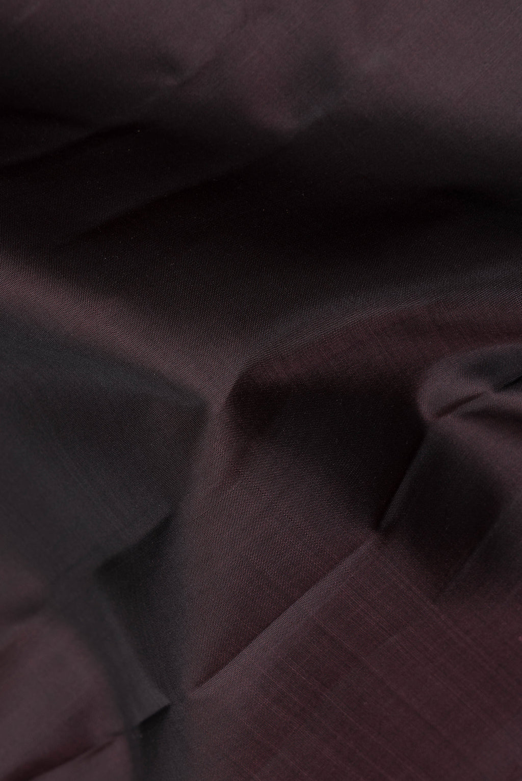 Close up of Pure Silk Brown Kanchipuram Saree with Plain Body and Zari Border.  displaying folds