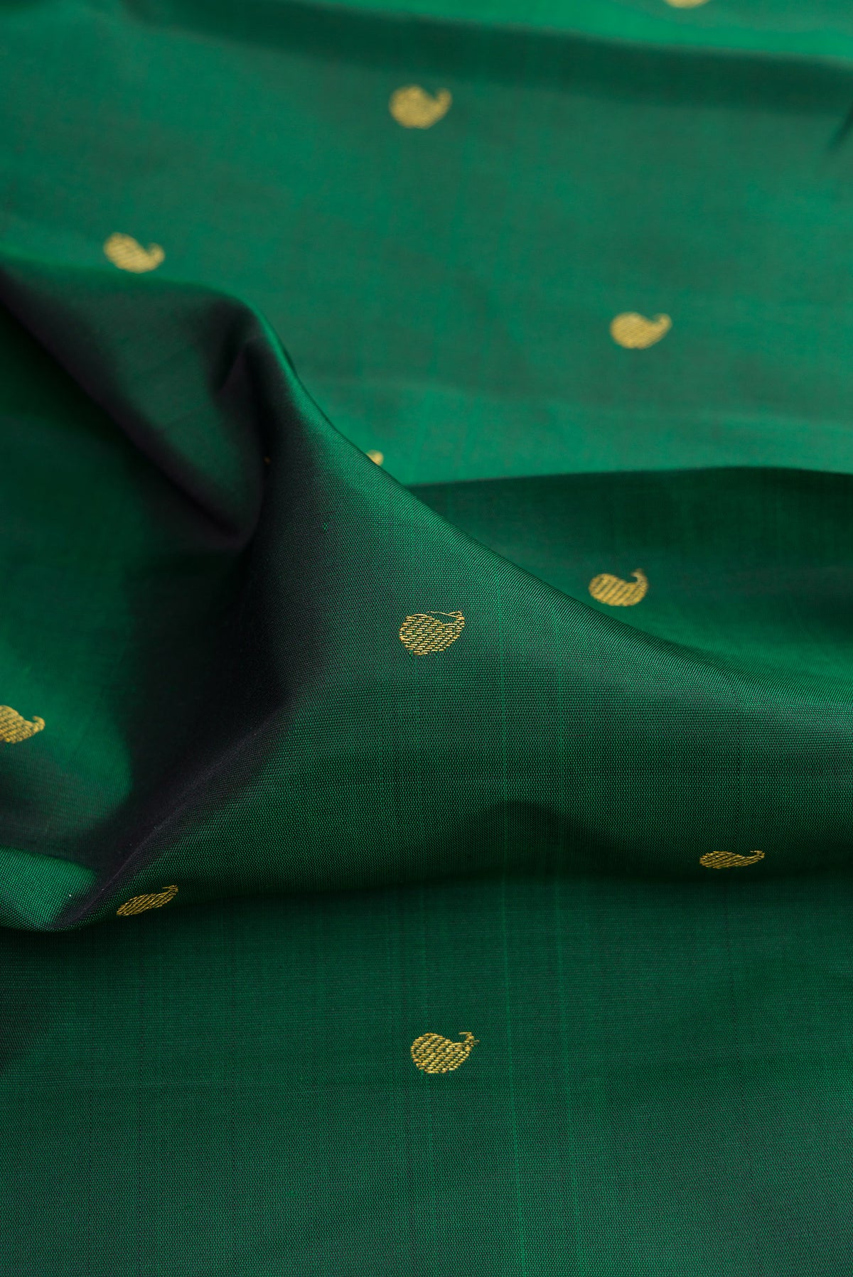 Close up of Pure Silk Bottle Green Kanchipuram Saree with Zari Butta on the body and Temple Border.  displaying folds